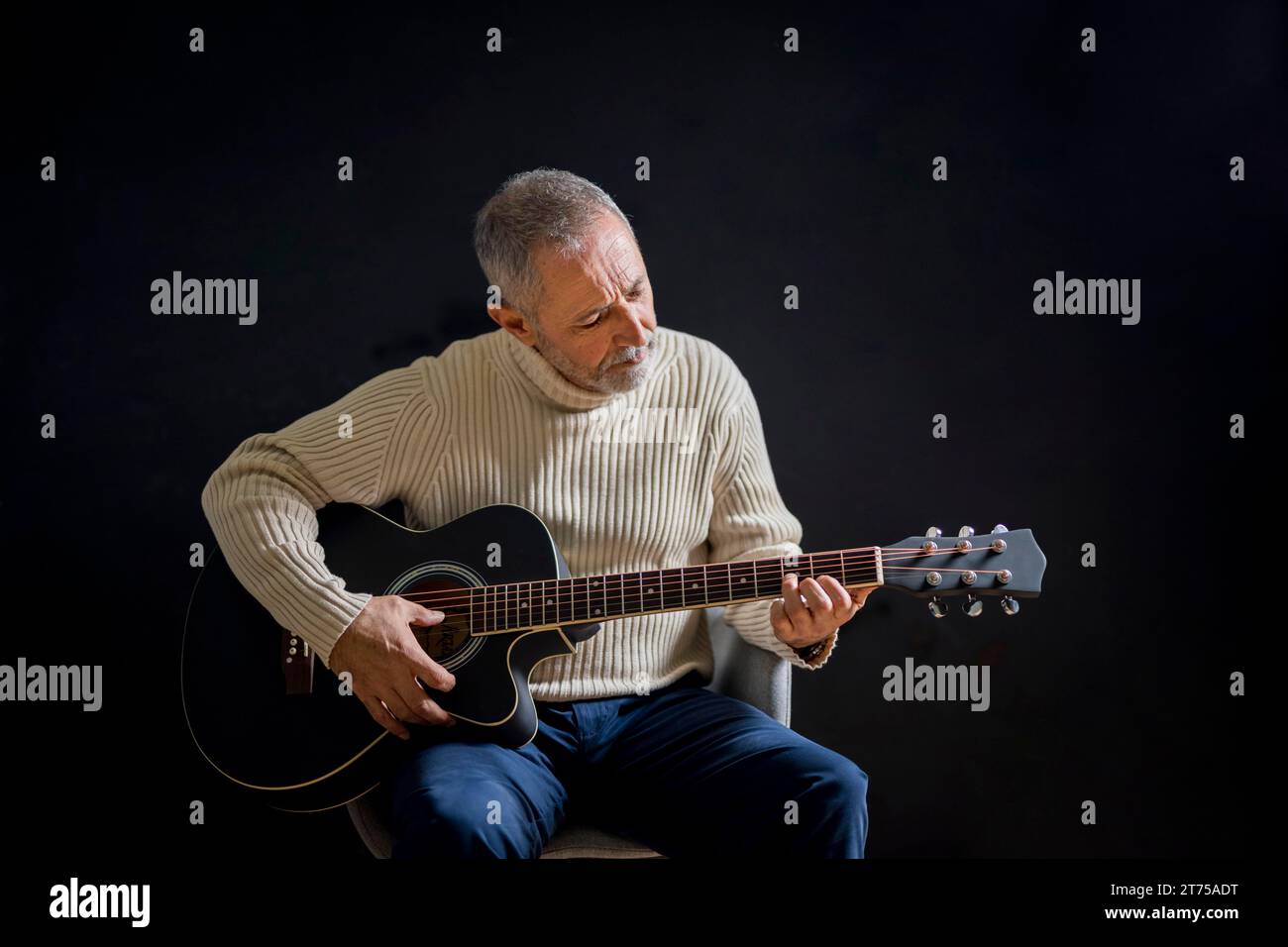 Un anziano medio che suona la chitarra Foto Stock