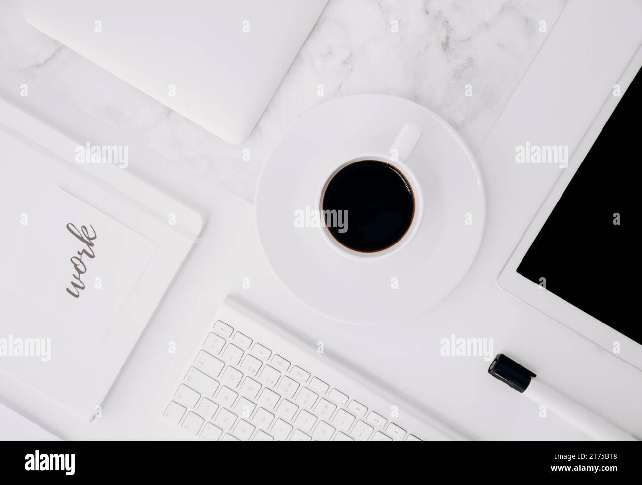 Diario di lavoro tavoletta digitale tazza da caffè tastiera pennarello nero scrivania bianca Foto Stock