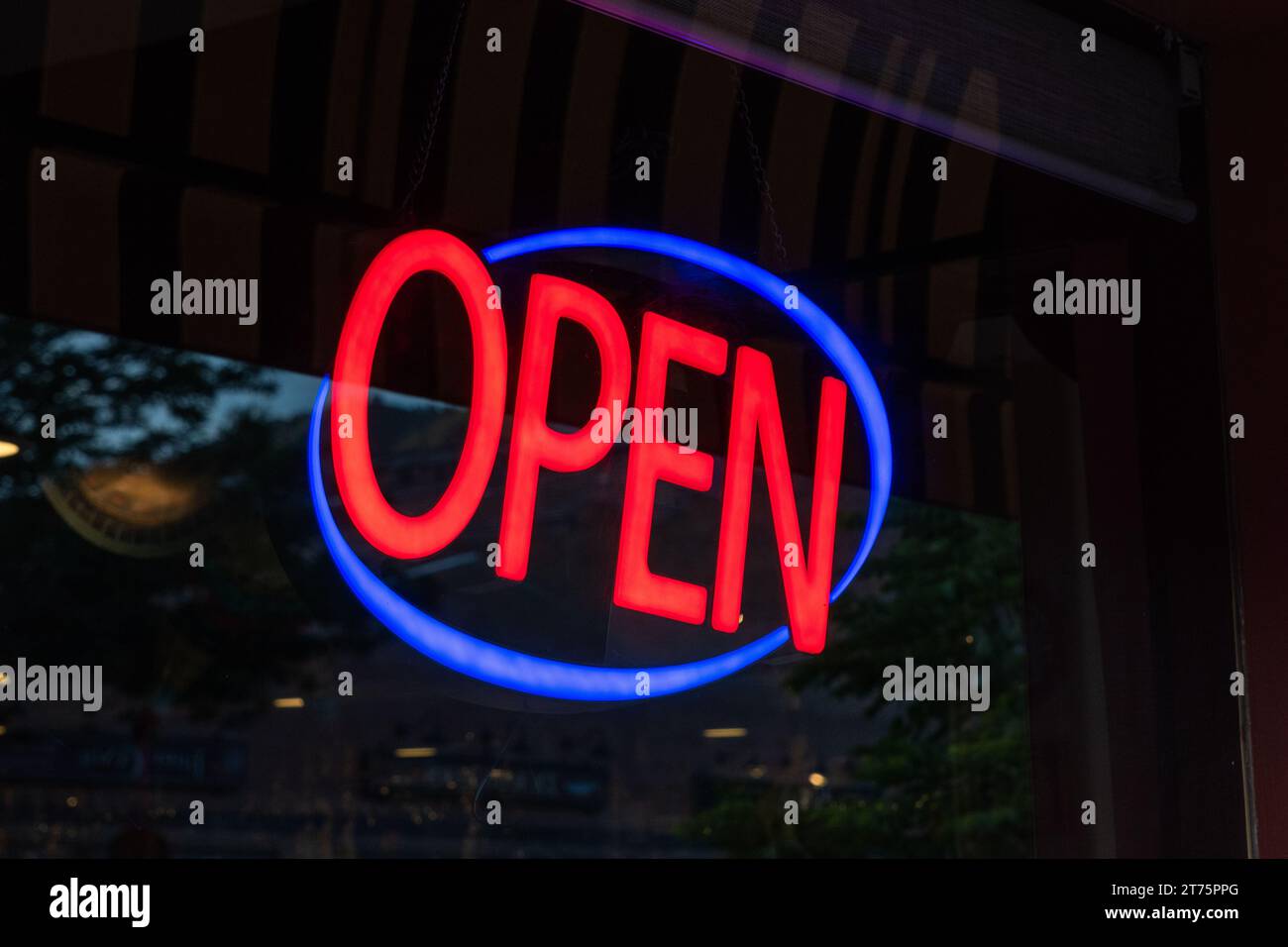 Il cartello aperto si illumina nella finestra anteriore di un negozio. Foto Stock