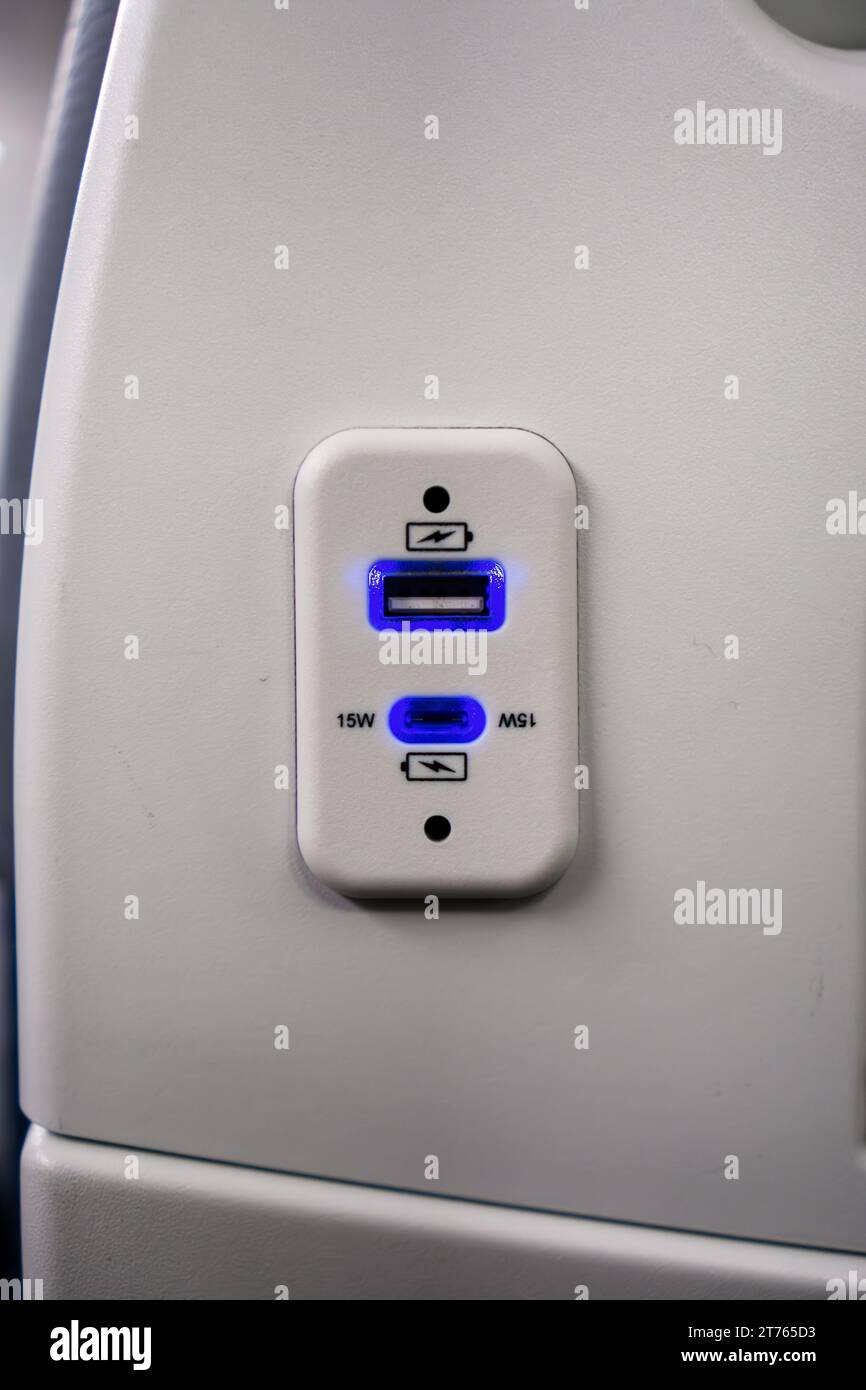 Porta di ricarica USB per dispositivi elettronici sul sedile dell'aereo Foto Stock