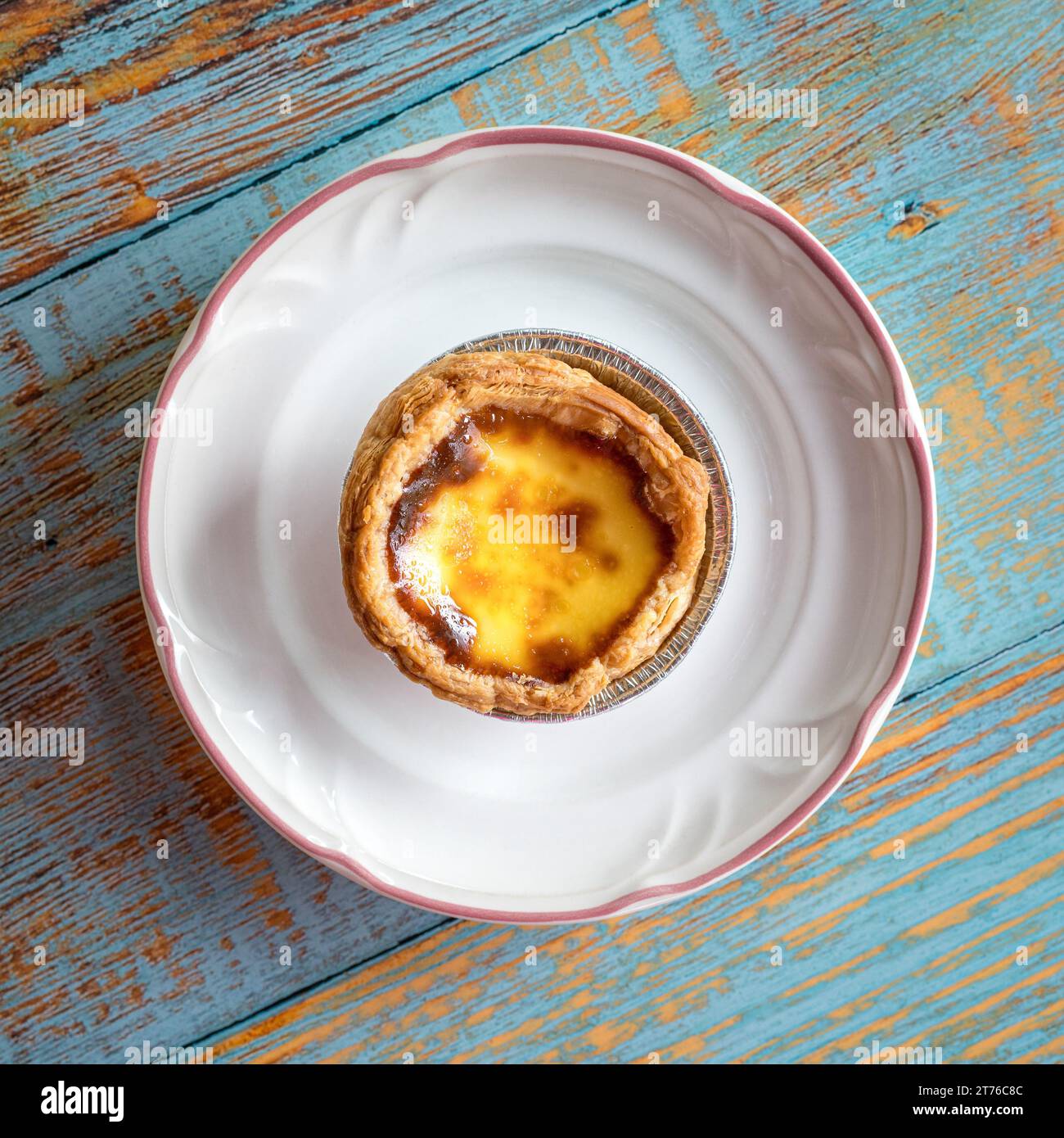 Crostata all'uovo portoghese su un piatto bianco. Vista dall'alto. Foto Stock