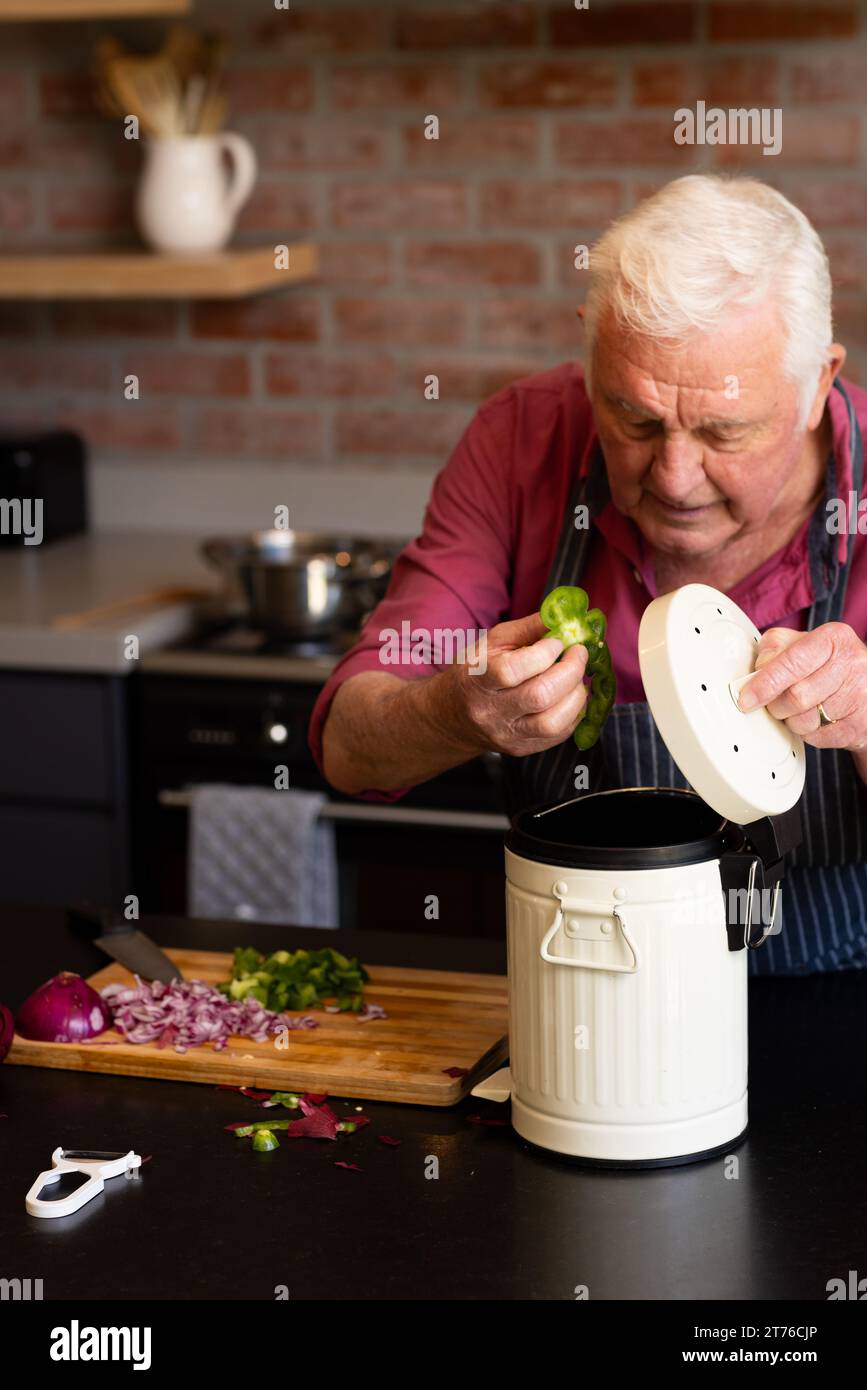 Uomo anziano caucasico che prepara cibo, compostaggio rifiuti vegetali in cucina, spazio copia Foto Stock