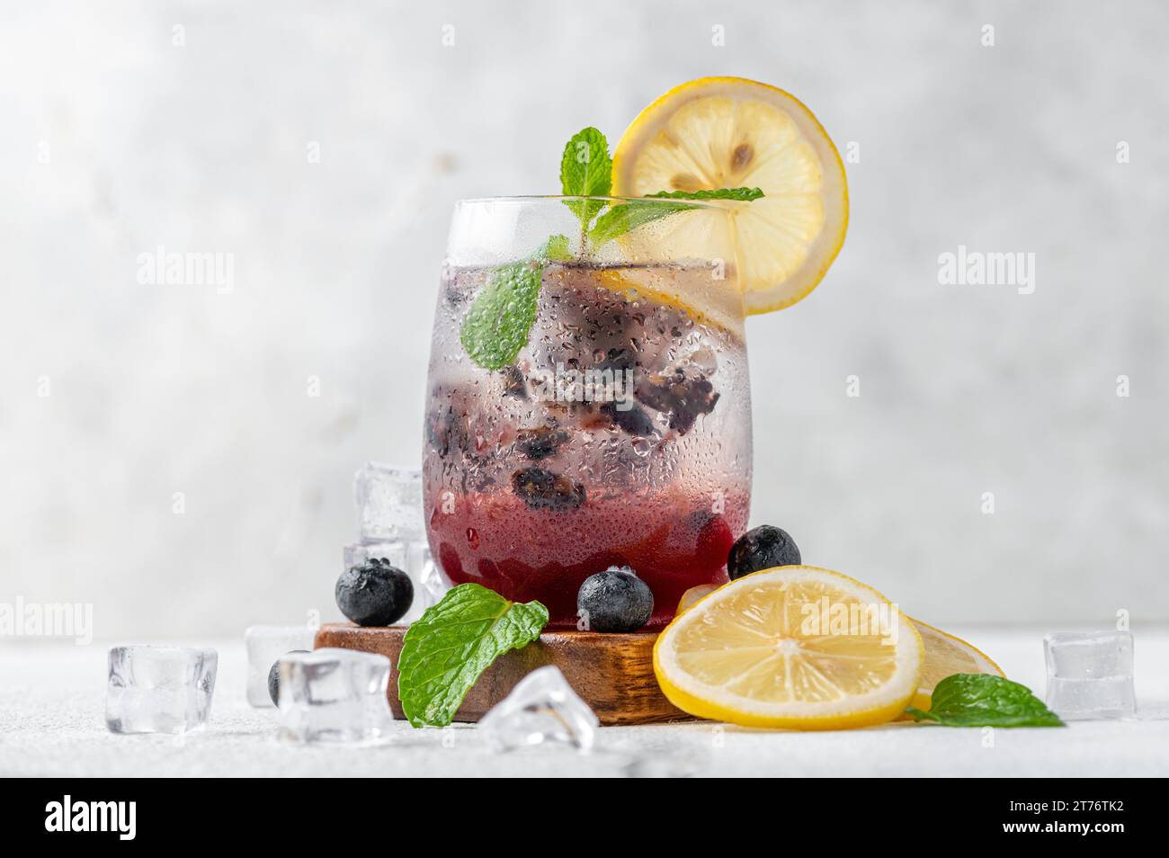 Una caraffa di mojito di mirtilli appena preparato, guarnita con pezzi di frutta colorati. Foto Stock