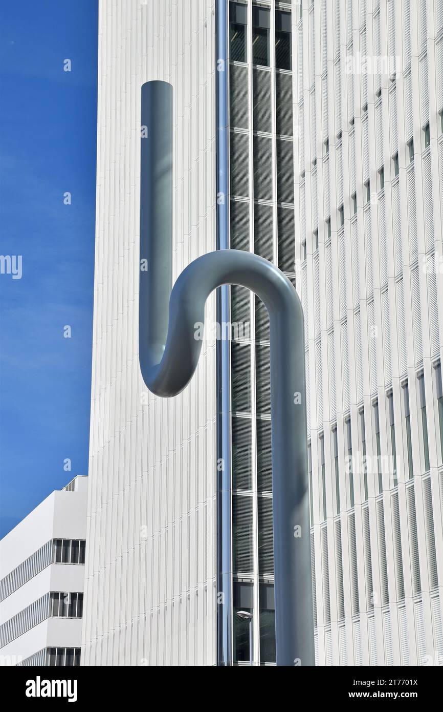 Un pezzo di scultura astratta nella riserva centrale di Grenzacherstrasse a Basilea, tubo di acciaio di grande diametro a forma di due curve a U congiunte Foto Stock