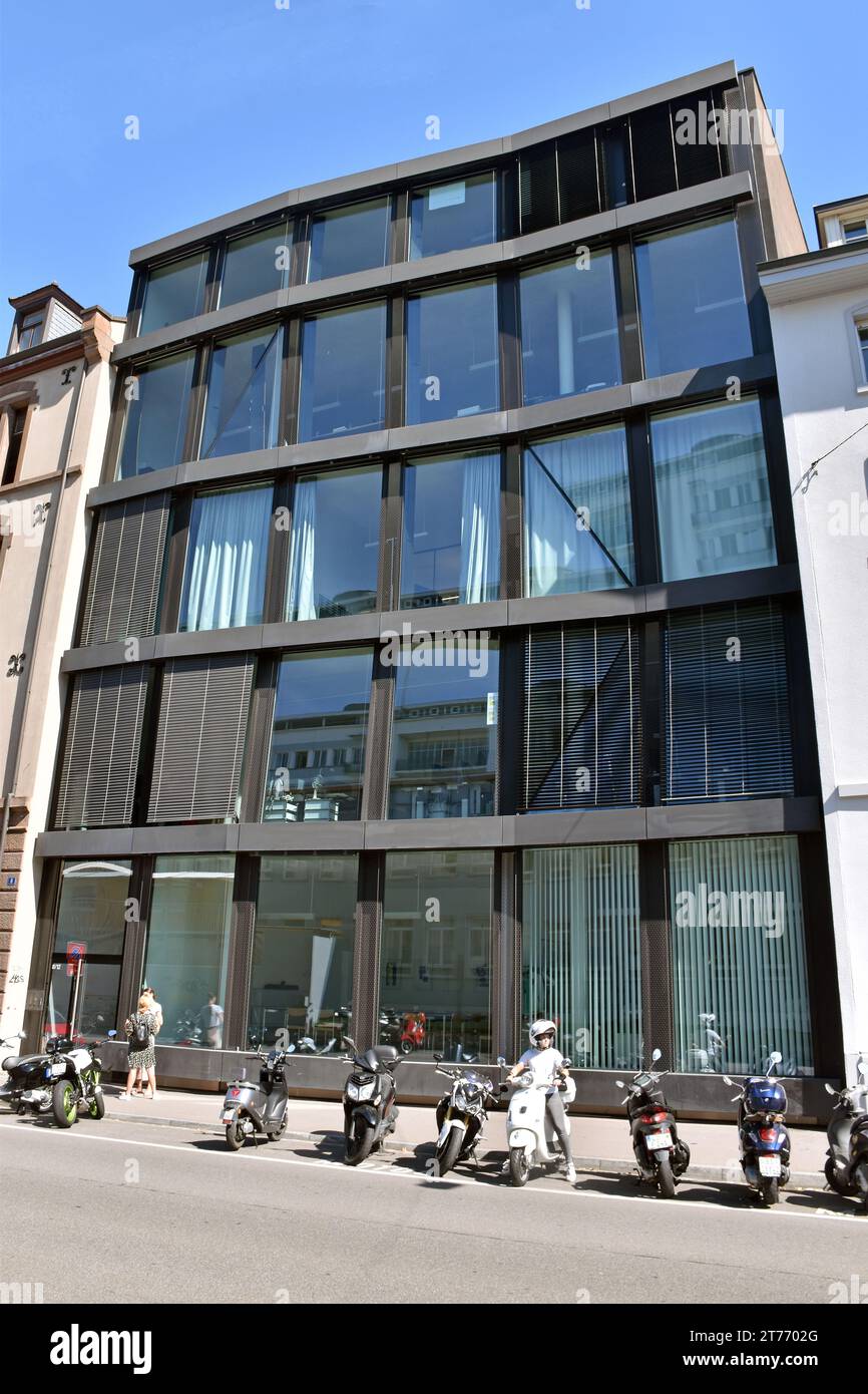 Edificio con struttura in acciaio, fronte piatto, 6 vani, 5 piani, 1 porta e 29 grandi lastre di vetro, la struttura è leggermente distorta, in un modo leggermente inquietante. Foto Stock