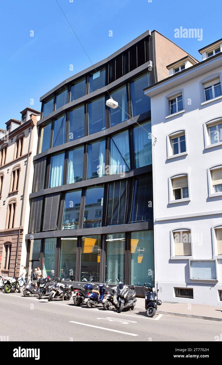 Edificio con struttura in acciaio, fronte piatto, 6 vani, 5 piani, 1 porta e 29 grandi lastre di vetro, la struttura è leggermente distorta, in un modo leggermente inquietante. Foto Stock