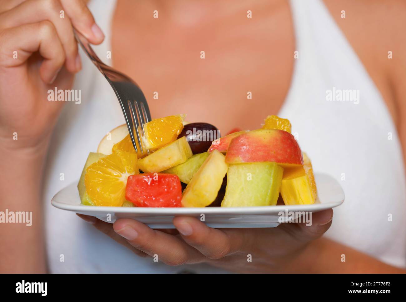 Primo piano di una giovane donna che tiene una ciotola di Macedonia di frutta Foto Stock