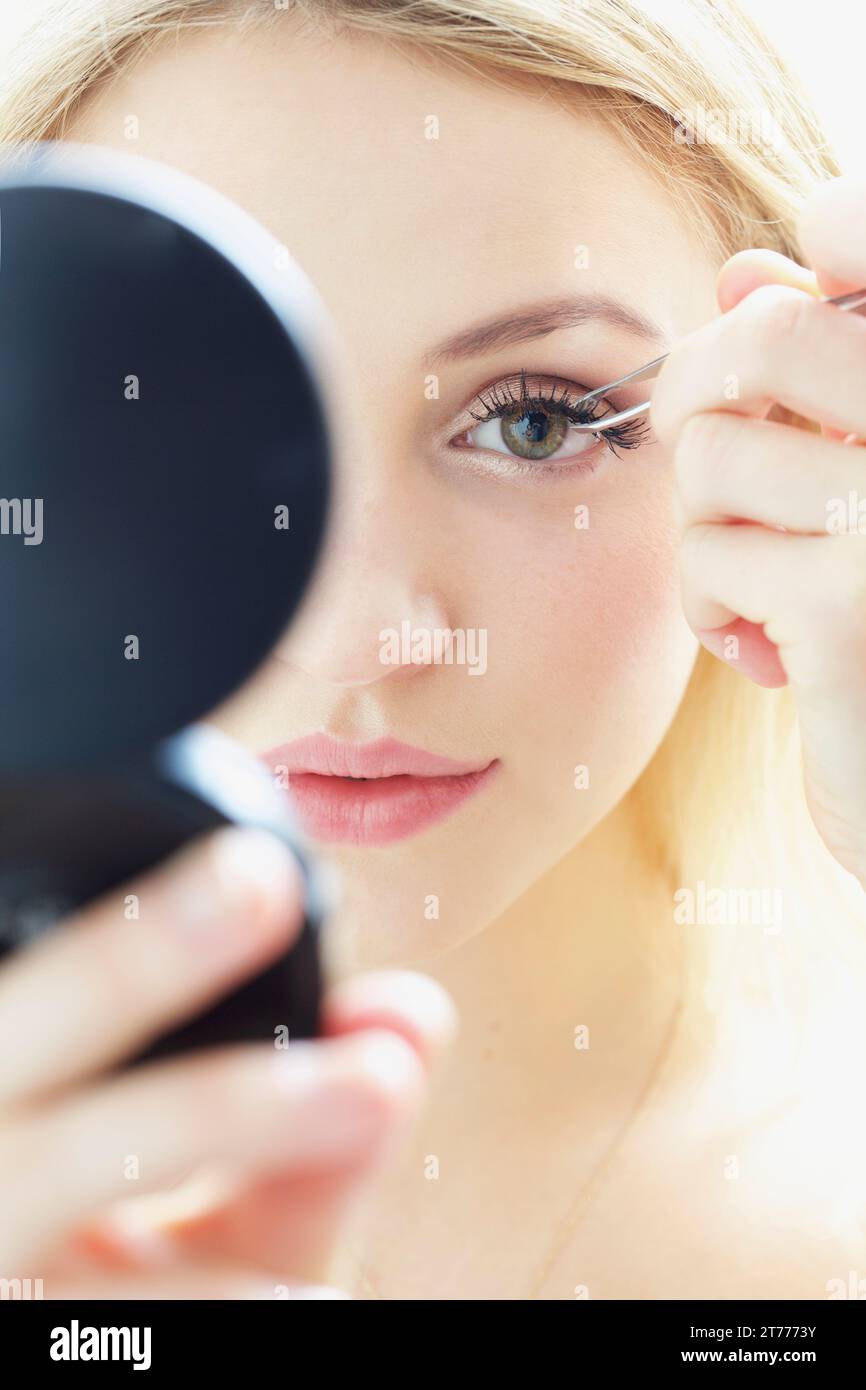 Close up della giovane donna applicazione Ciglia finte Foto Stock