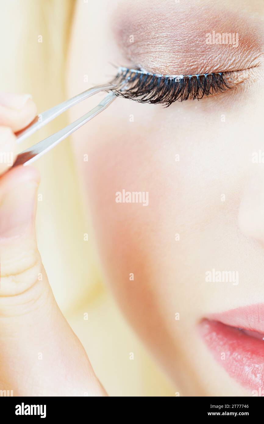 Extreme close up della donna applicazione Ciglia finte Foto Stock