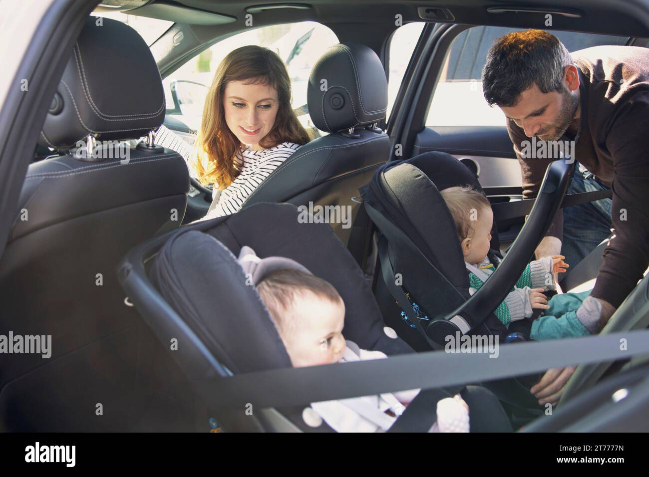 Fissaggio uomo bambino seggiolino di sicurezza in auto Foto Stock