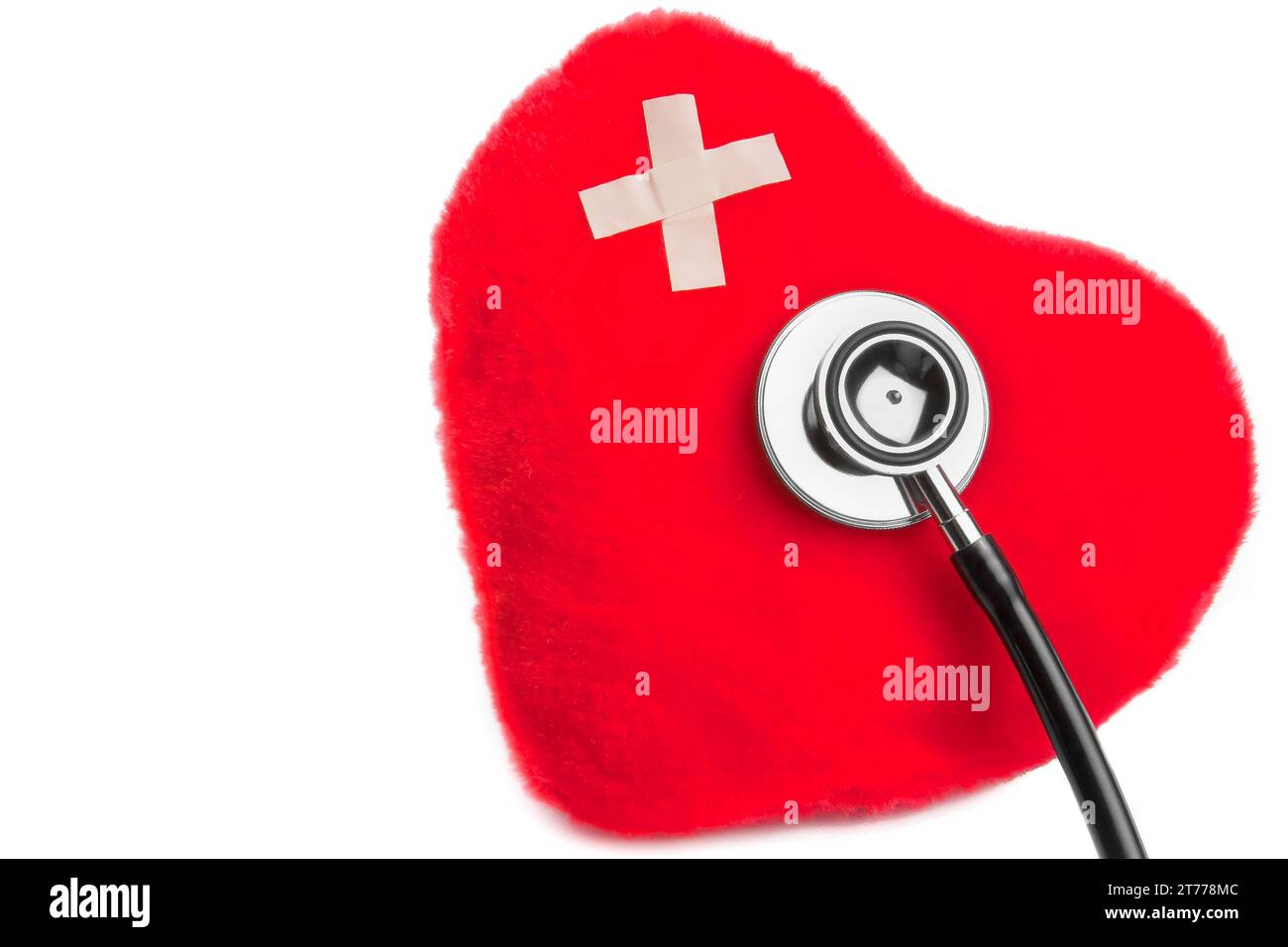 cuore di giocattoli coccolosi con patch vicino allo stetoscopio su sfondo bianco con spazio per il testo Foto Stock