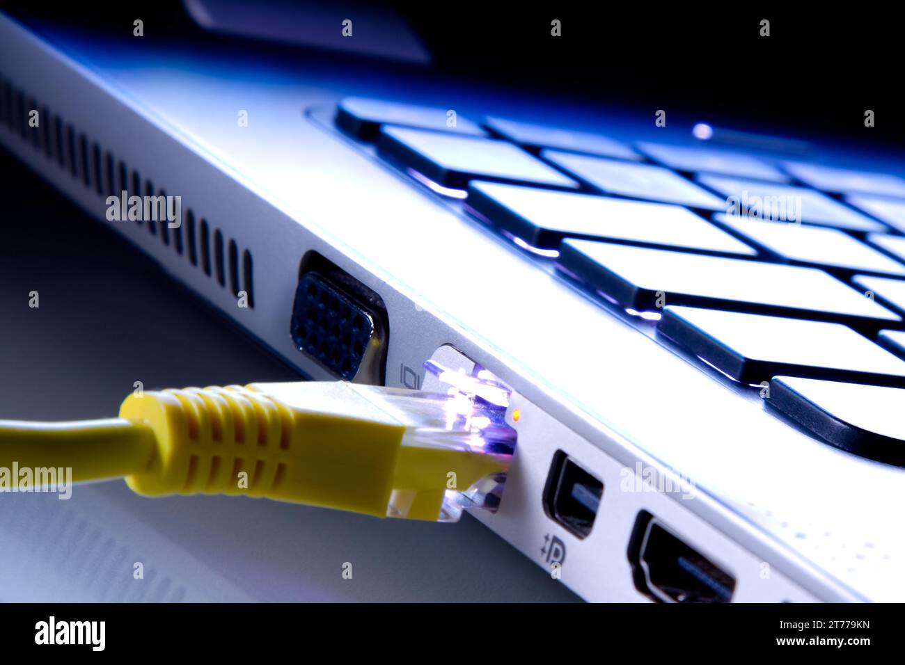 cavo di rete collegato al laptop come sfondo blu Foto Stock