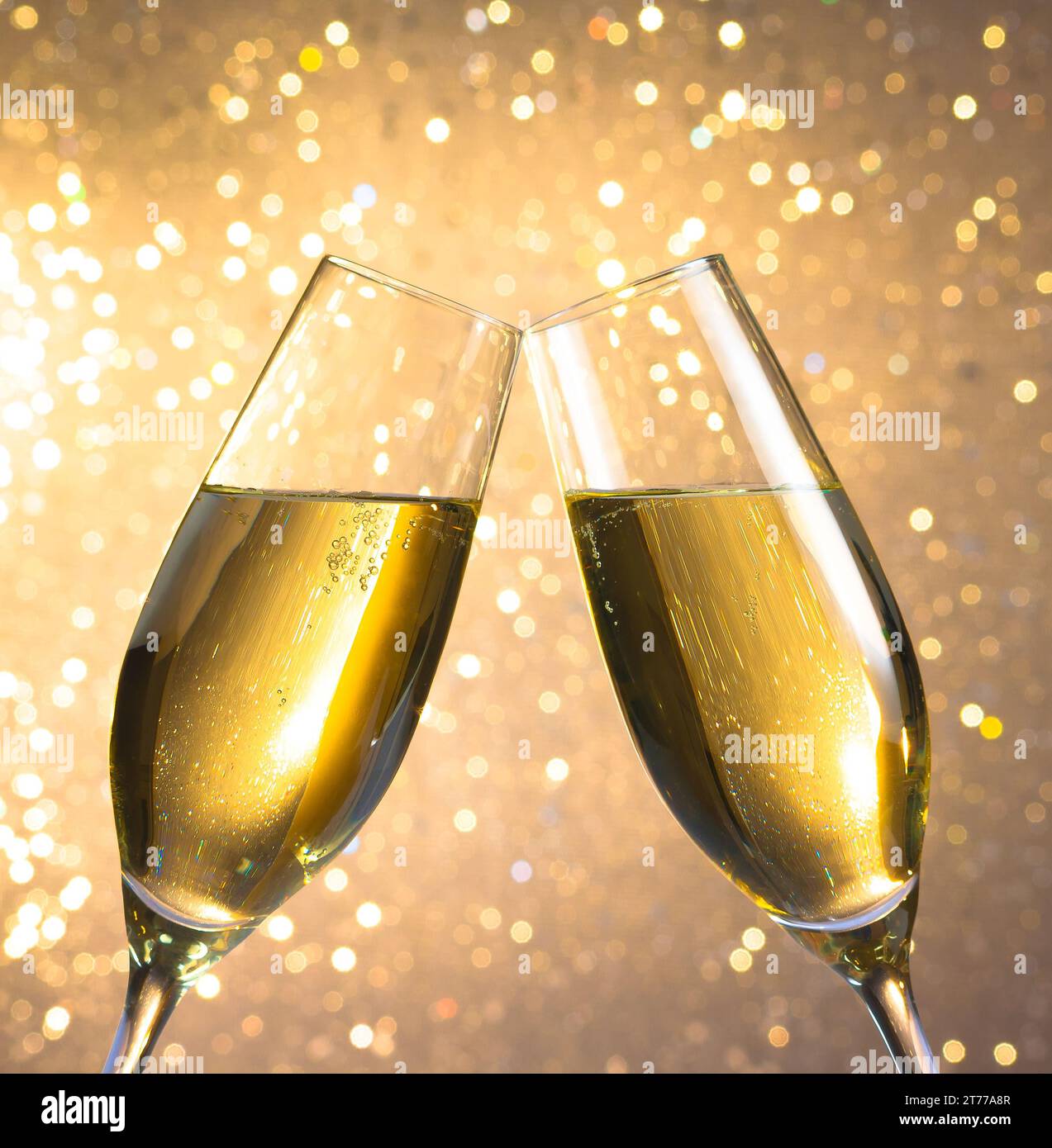 un paio di flauti di champagne con bolle d'oro fa il tifo su uno sfondo bokeh leggero Foto Stock