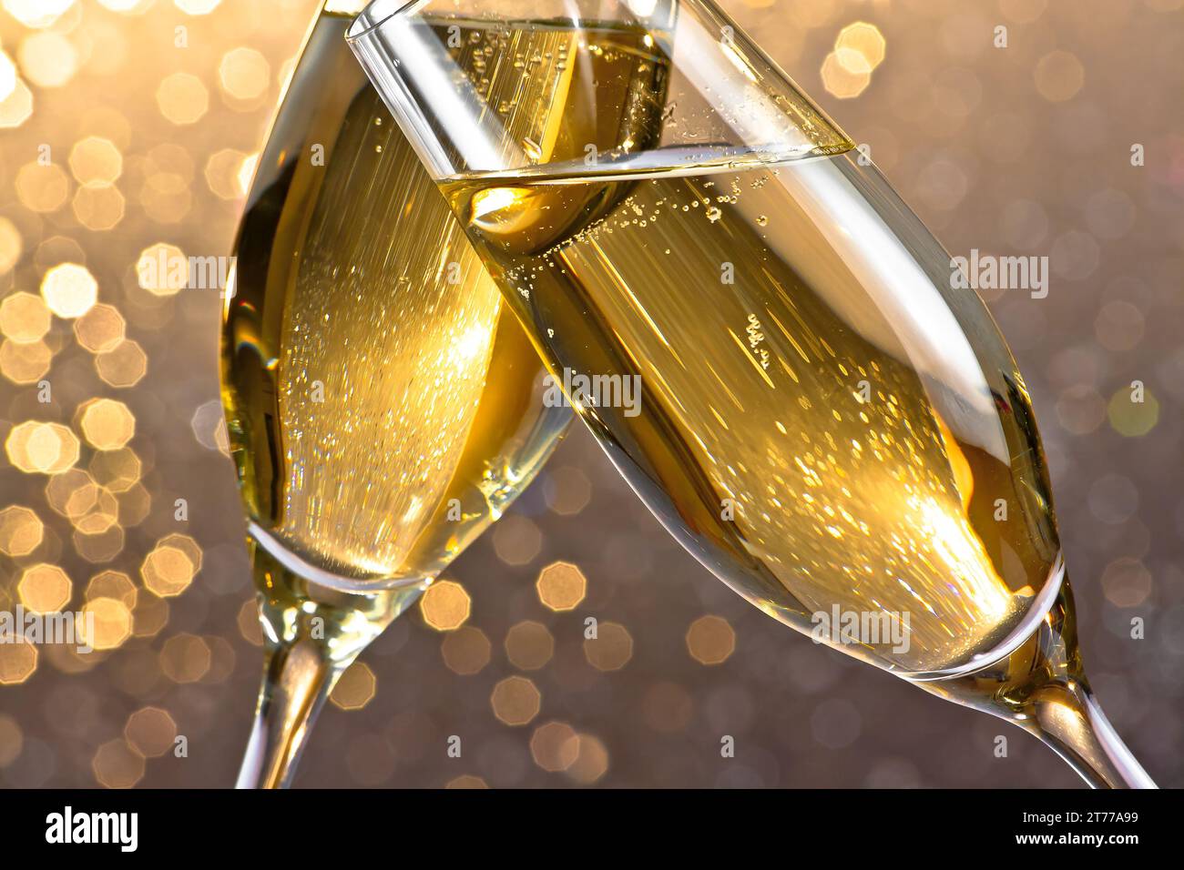 dettaglio di un flute di champagne con bollicine dorate per esultare su uno sfondo bokeh leggero Foto Stock