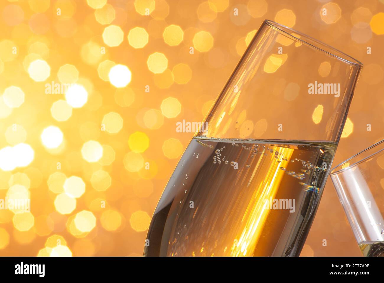 i flauti di champagne fanno il tifo su sfondo bokeh chiaro dorato con spazio per il testo Foto Stock
