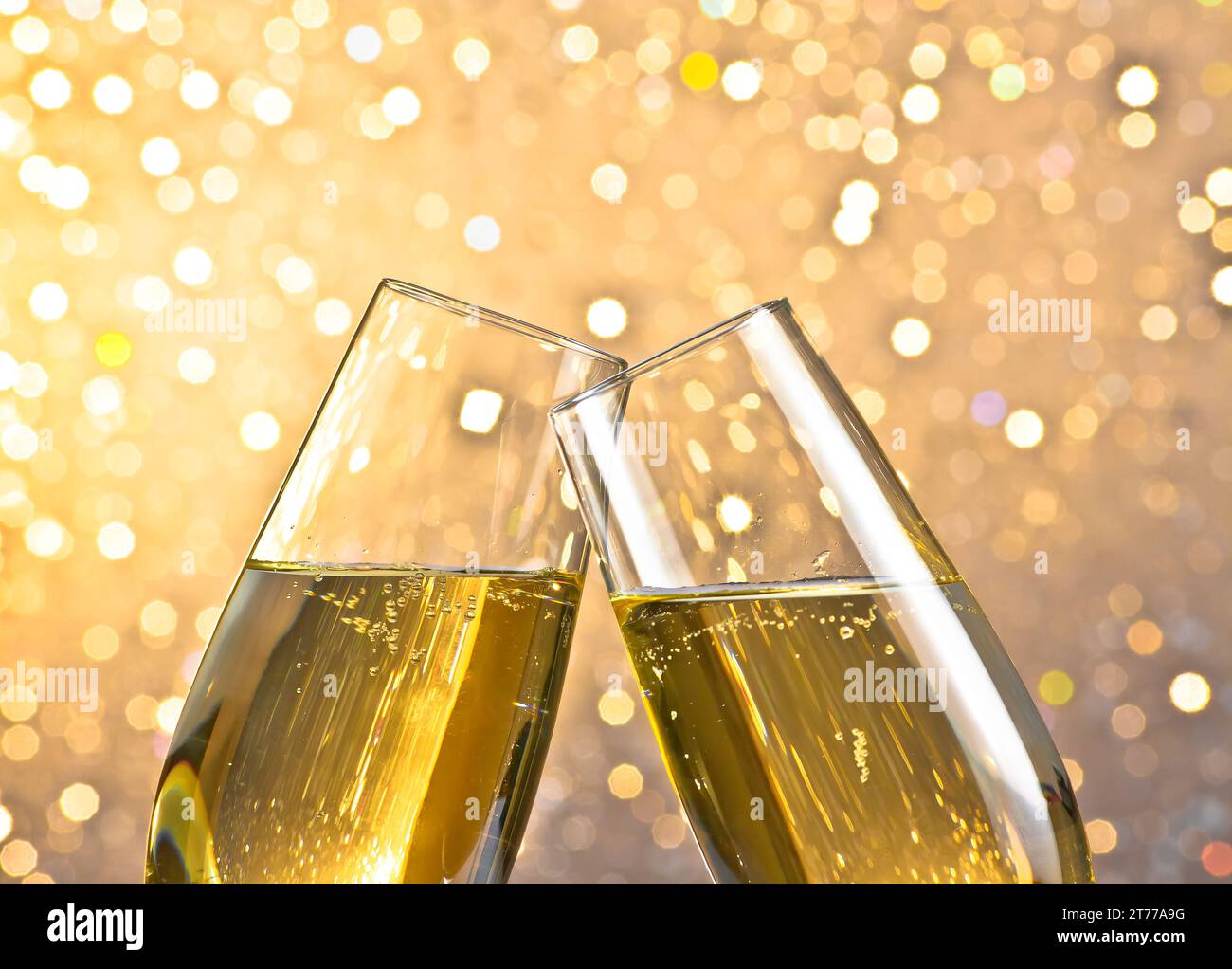 dettaglio di un flute di champagne con bolle d'oro che esaltano lo sfondo bokeh leggero con spazio per il testo Foto Stock