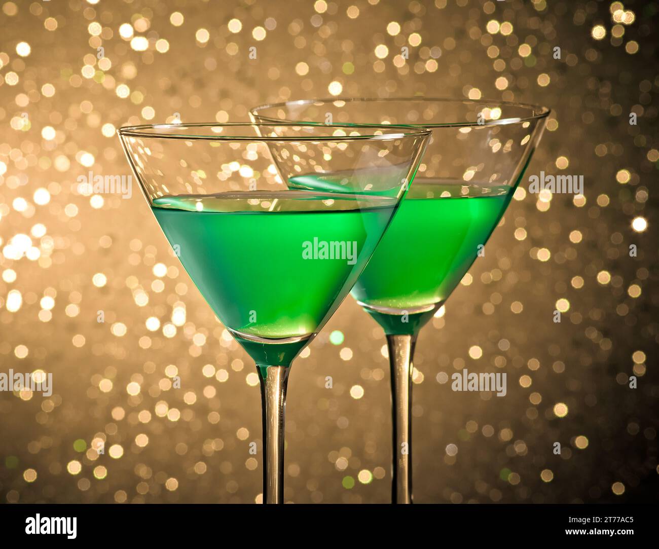 bicchieri di cocktail verde su sfondo bokeh chiaro e scuro sul tavolo Foto Stock