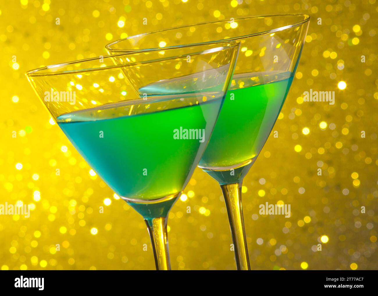 due bicchieri di cocktail verde su sfondo bokeh chiaro e dorato Foto Stock