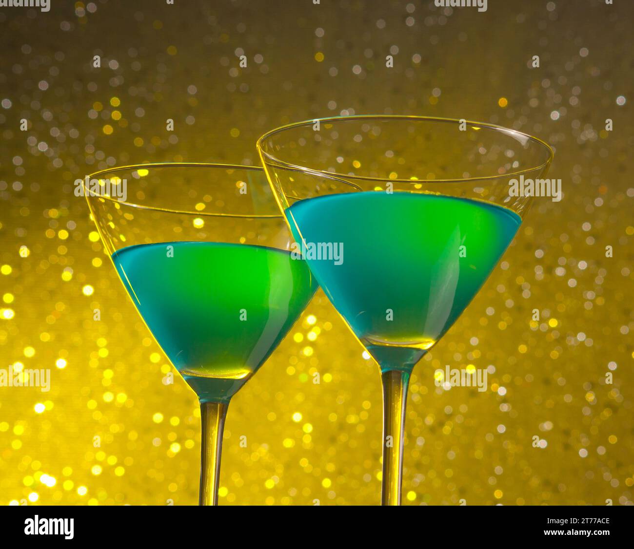 un paio di due bicchieri di cocktail verde su sfondo bokeh chiaro e dorato Foto Stock