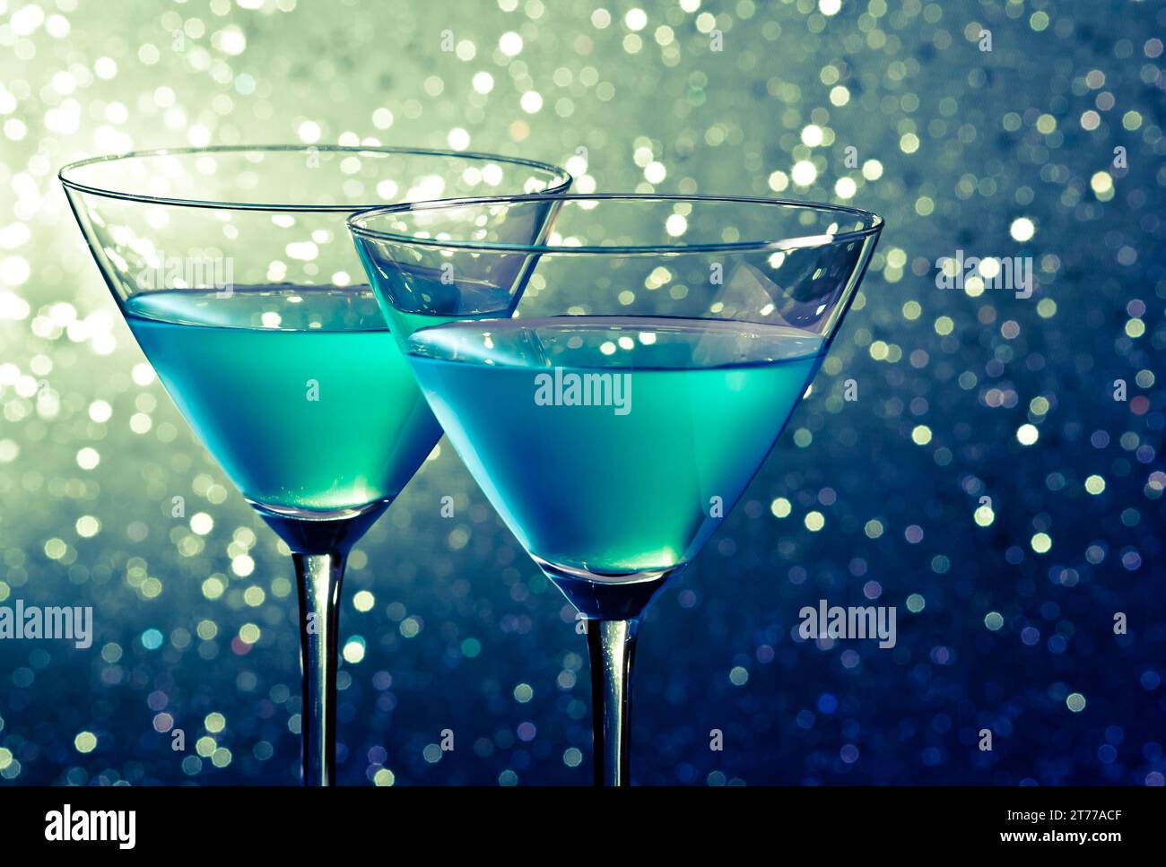 due bicchieri di cocktail blu su sfondo bokeh chiaro e verde scuro sul tavolo Foto Stock