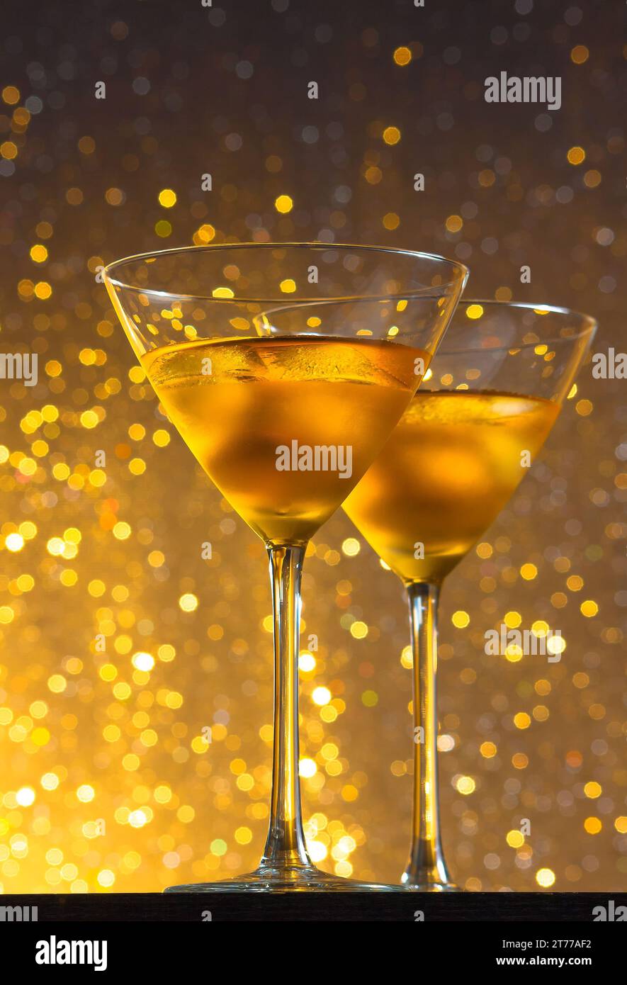 vista dal basso dei bicchieri di cocktail fresco con ghiaccio su sfondo chiaro color oro sul tavolo da bar Foto Stock