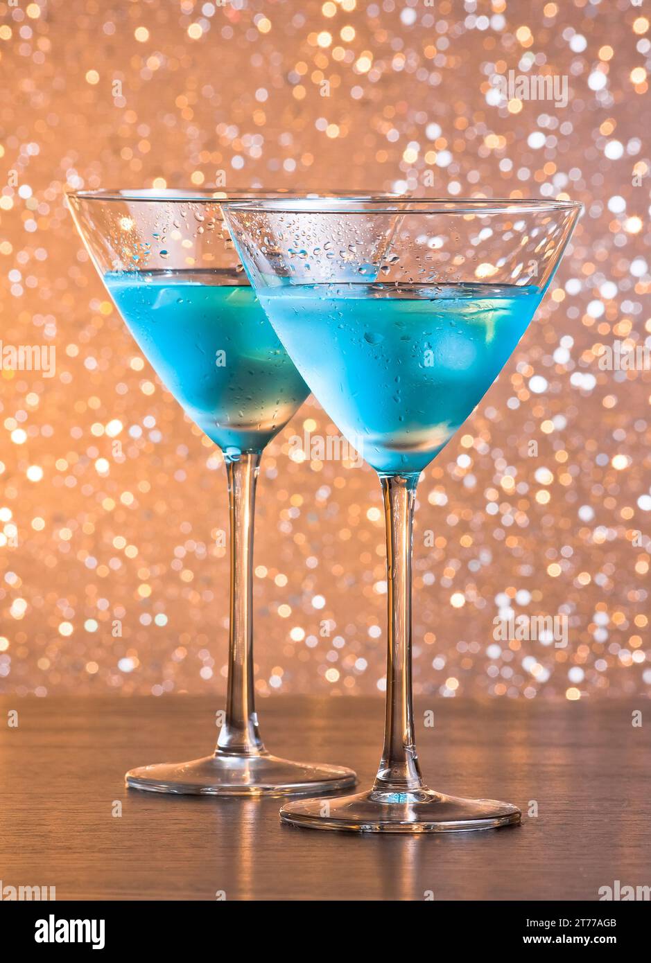 bicchieri di fresco cocktail blu con ghiaccio su sfondo bokeh chiaro e dorato sul tavolo da bar Foto Stock