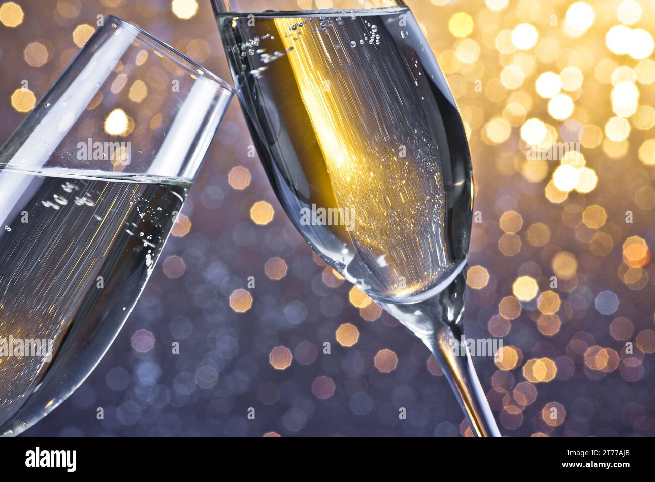 due flauti di champagne con bolle d'oro fanno il tifo su sfondo bokeh chiaro con spazio per il testo Foto Stock