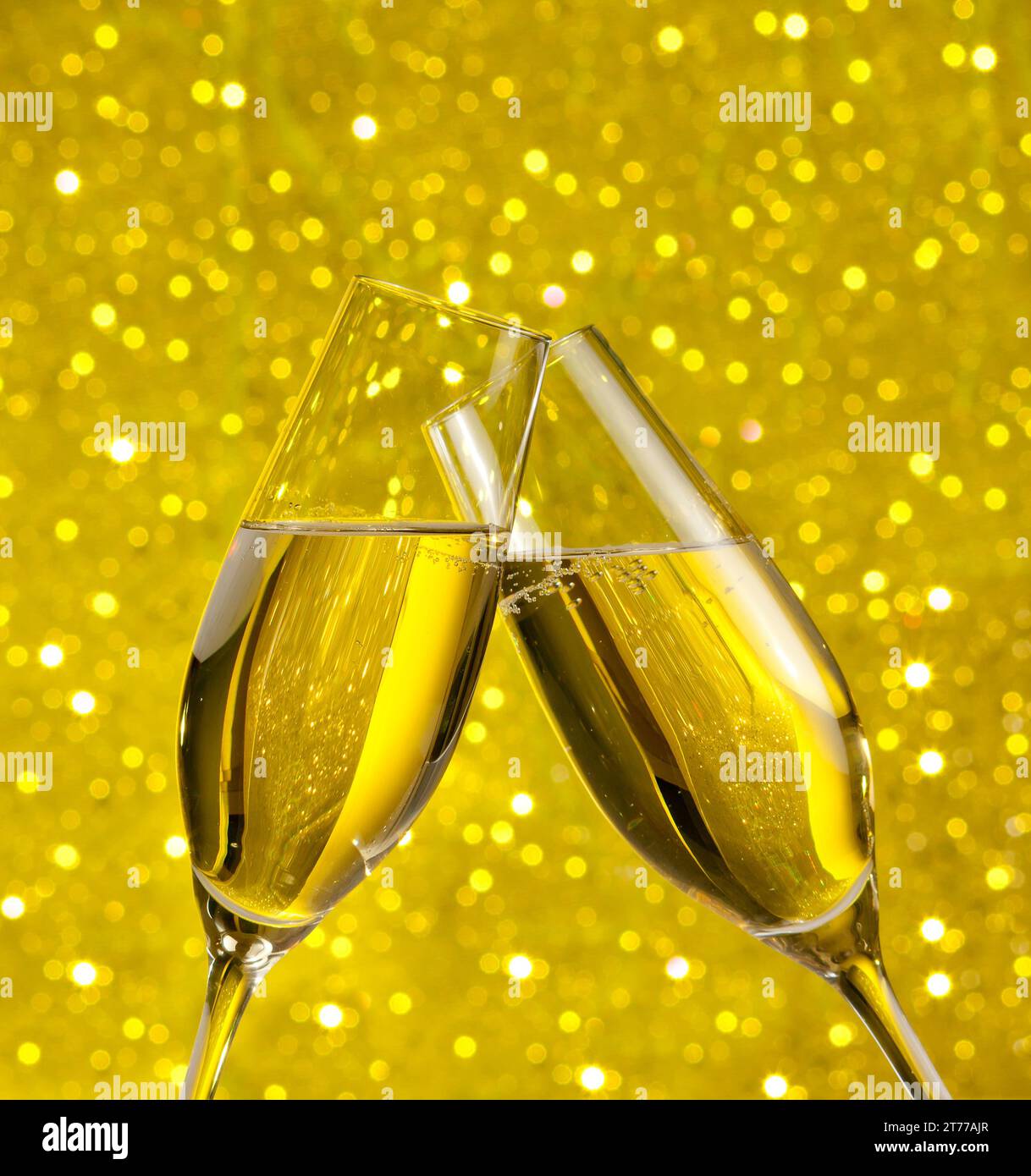 flauti di champagne con bolle d'oro fanno il tifo su sfondo bokeh chiaro e dorato Foto Stock