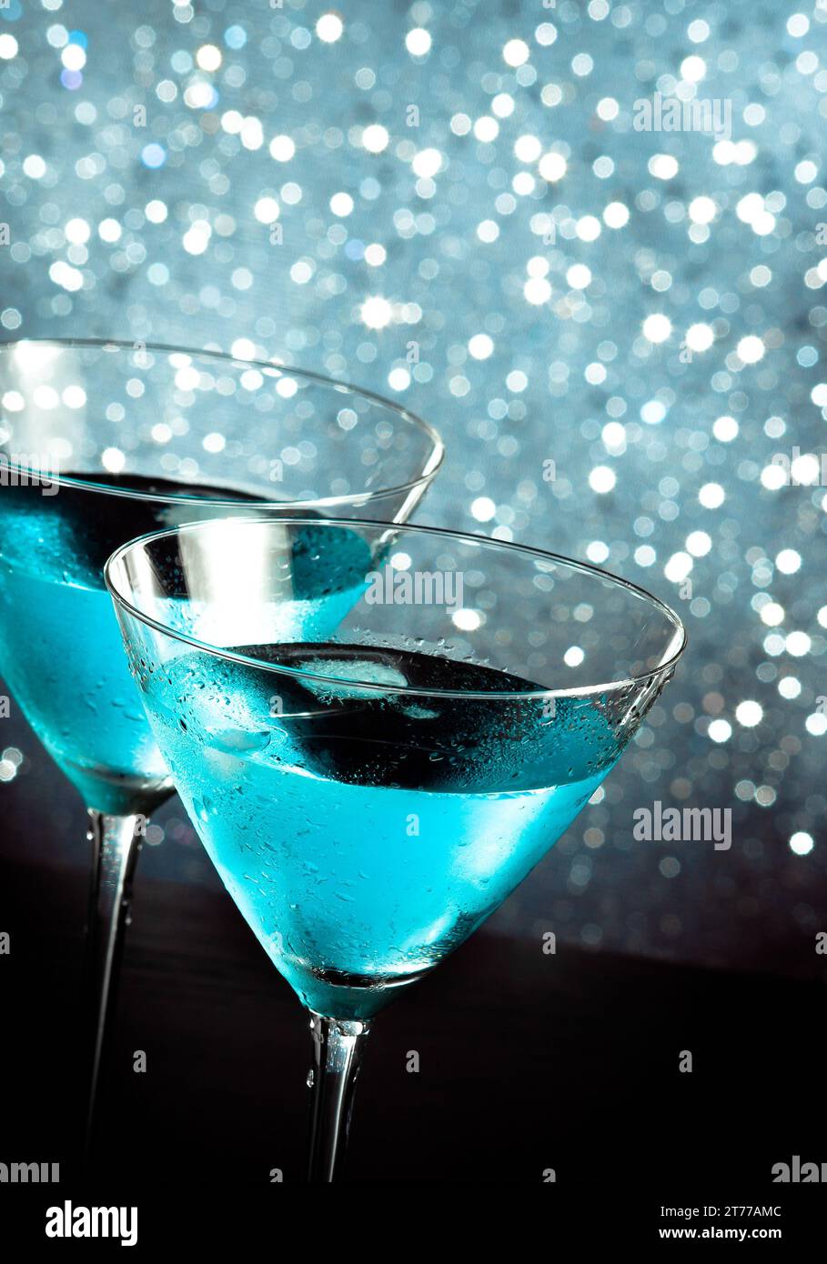 un paio di bicchieri di fresco cocktail blu con ghiaccio su sfondo bokeh chiaro blu sul tavolo da bar Foto Stock