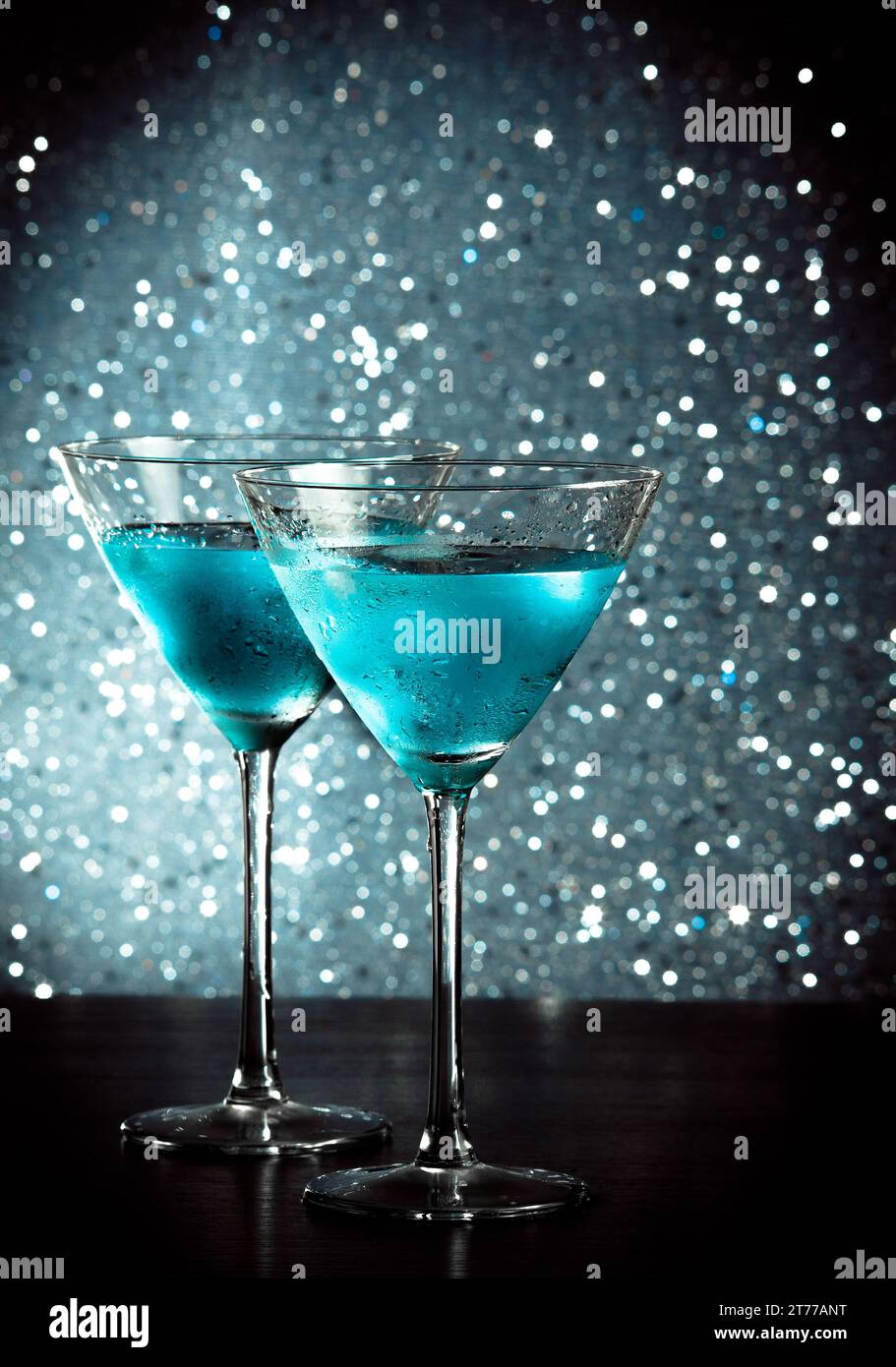 bicchieri di fresco cocktail blu con ghiaccio su sfondo bokeh chiaro e blu sul tavolo da bar Foto Stock