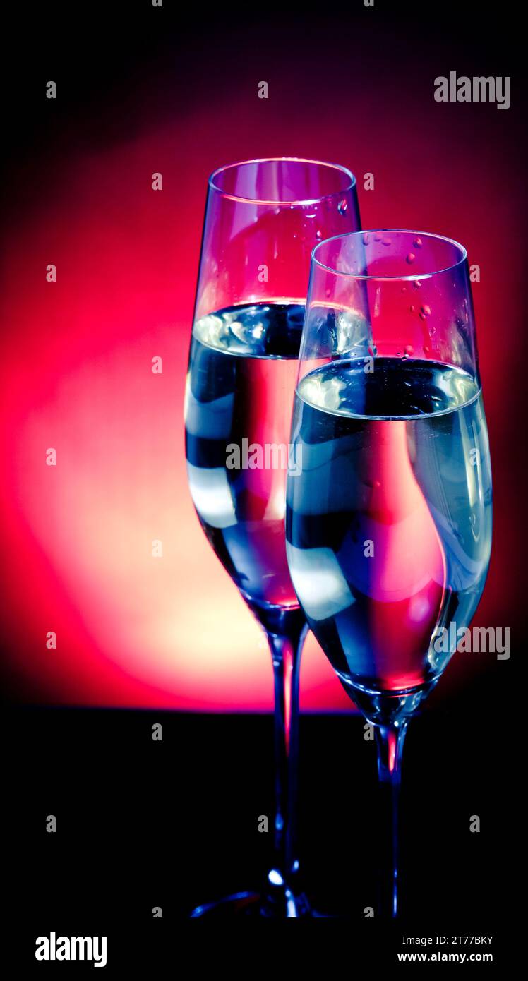 flauti di champagne con bolle dorate su sfondo blu scuro e viola chiaro con spazio per il testo Foto Stock