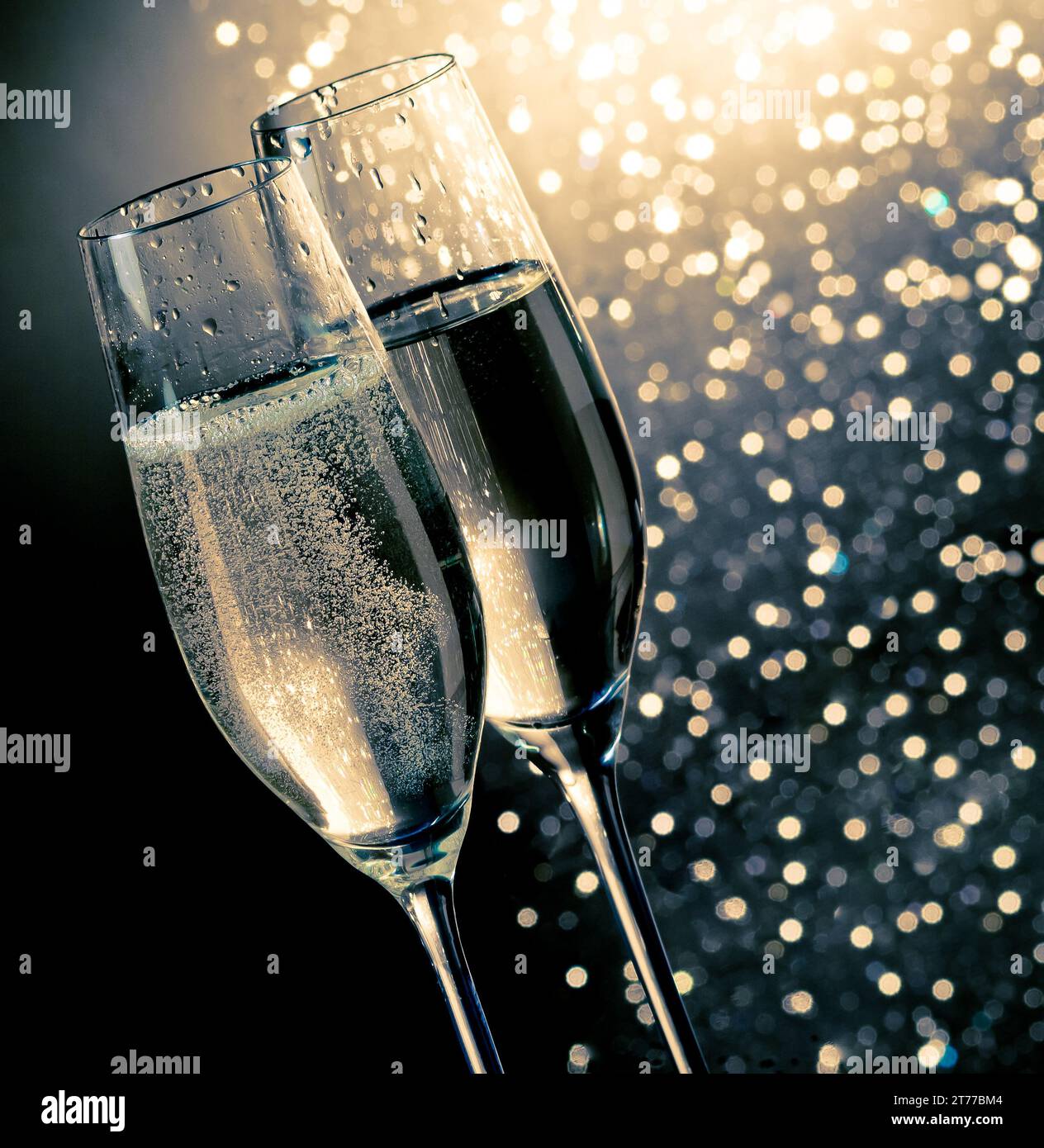 flauti di champagne con bolle dorate su sfondo bokeh chiaro blu scuro con spazio per il testo Foto Stock