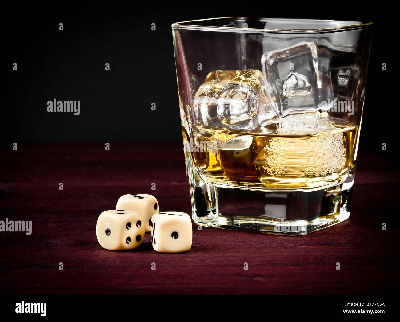 dadi vicino al bicchiere di whisky sul vecchio tavolo di legno, concetto di gioco Foto Stock