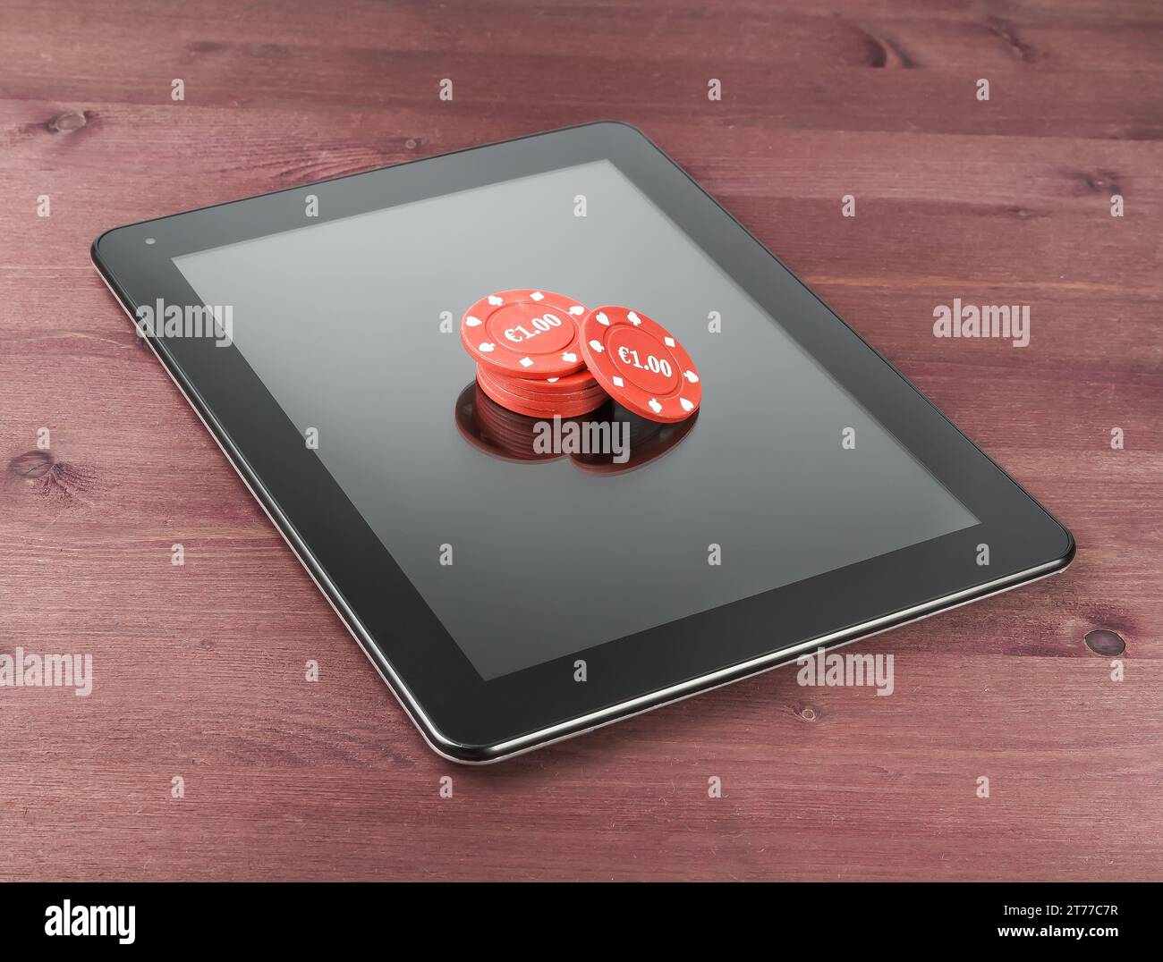 red gambling chips su tablet pc digitale su vecchio tavolo di legno, concetto di gioco texas online Foto Stock