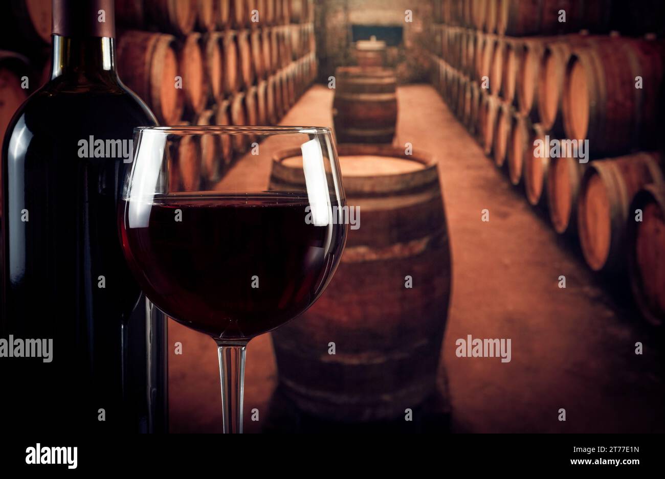 bicchiere di vino vicino alla bottiglia nella vecchia cantina con botti con spazio per il testo Foto Stock