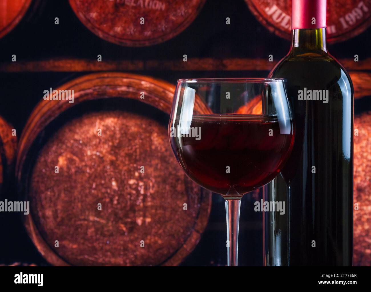bicchiere di vino vicino alla bottiglia nella vecchia cantina con fondo in botti Foto Stock