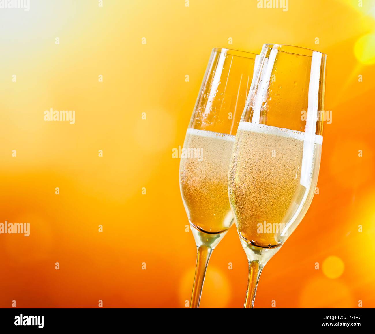 flute di champagne con bolle dorate su sfondo chiaro dorato con spazio per il testo Foto Stock
