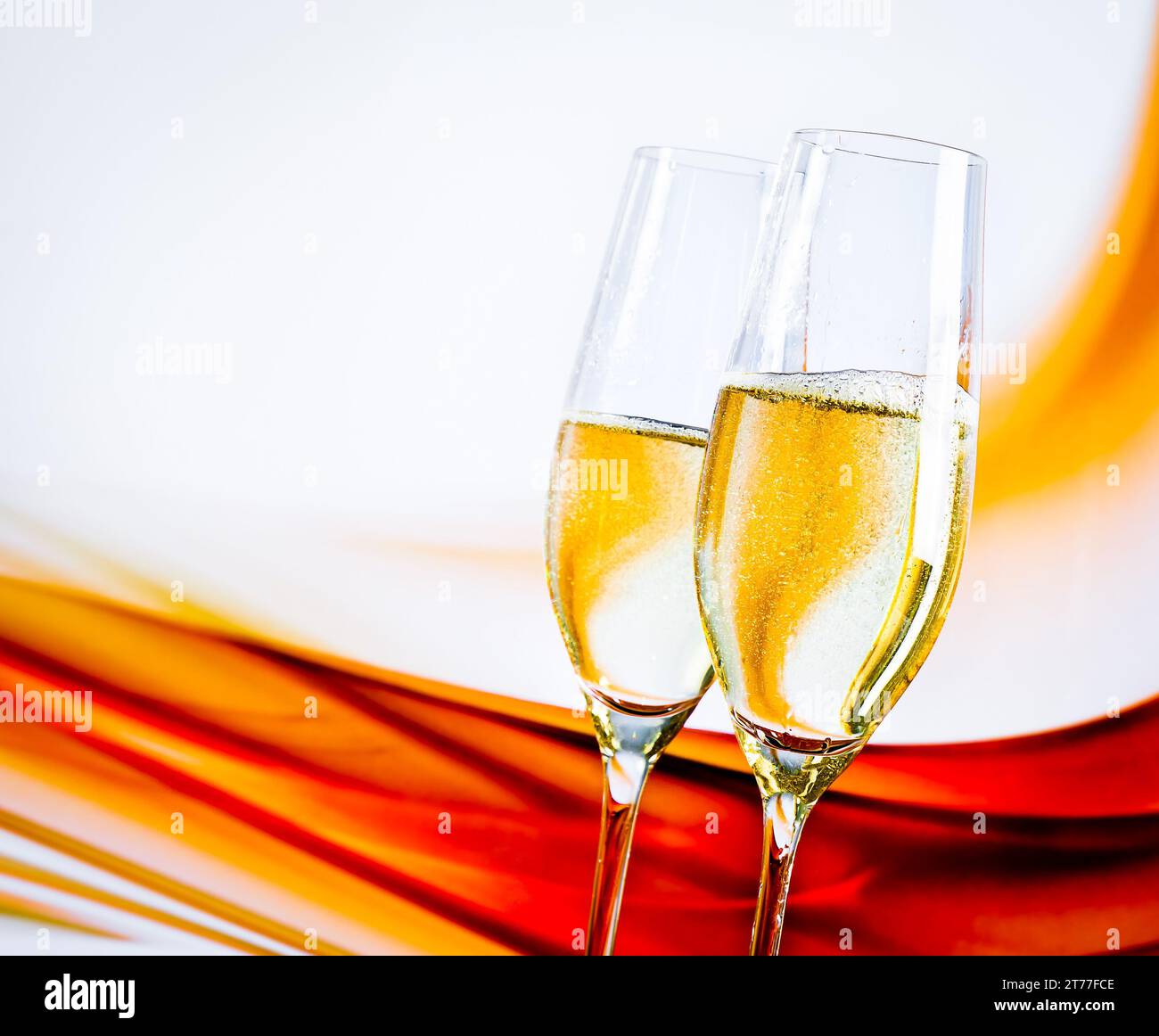 un paio di flute di champagne con bolle dorate su sfondo chiaro sfocato e spazio per il testo Foto Stock