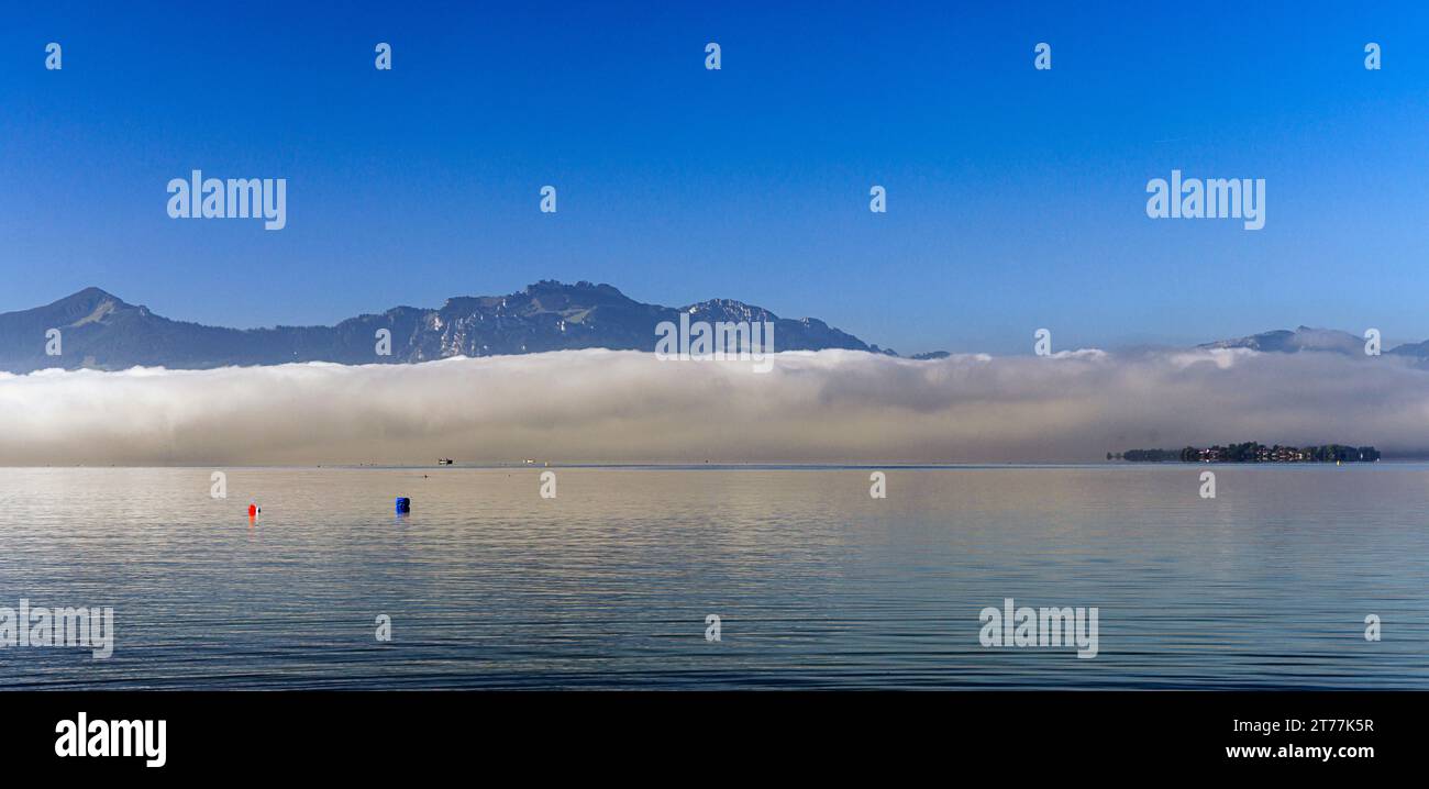 Muro di nebbia al sole sul lago meridionale di fronte a Kampenwand, Germania, Baviera, lago Chiemsee Foto Stock