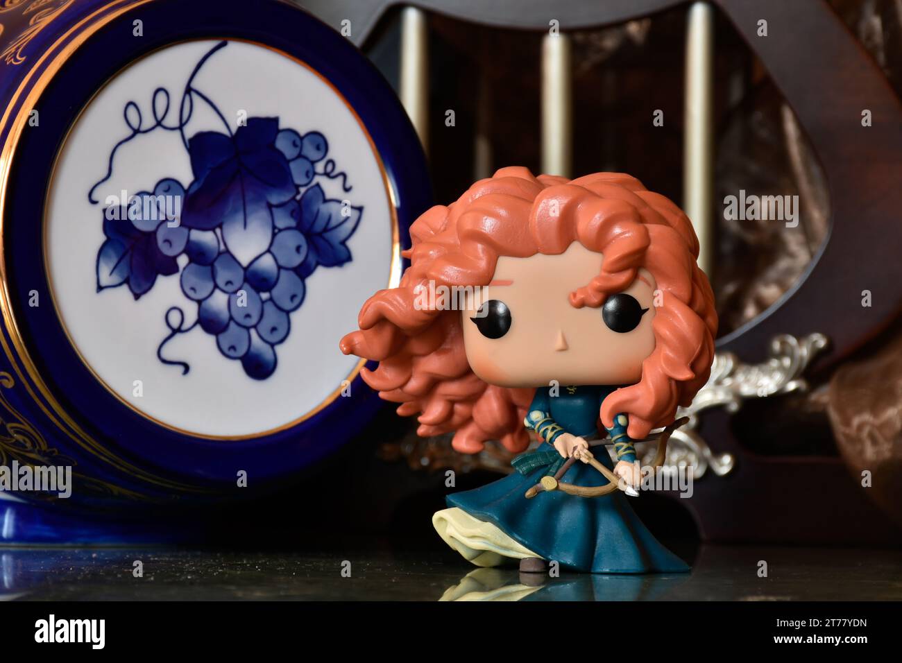 Funko Pop action figure della principessa Merida con arco e freccia del film d'animazione Brave. Castello medievale, favoloso regno, fusto blu porcellana. Foto Stock