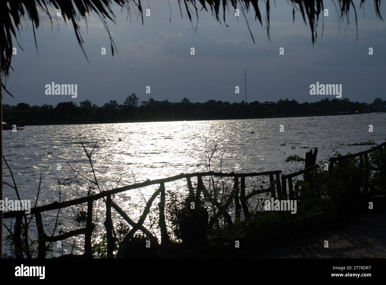 Il tramonto come ramo del fiume Mekong scorre attraverso il delta del Mekong nel sud del Vietnam Foto Stock