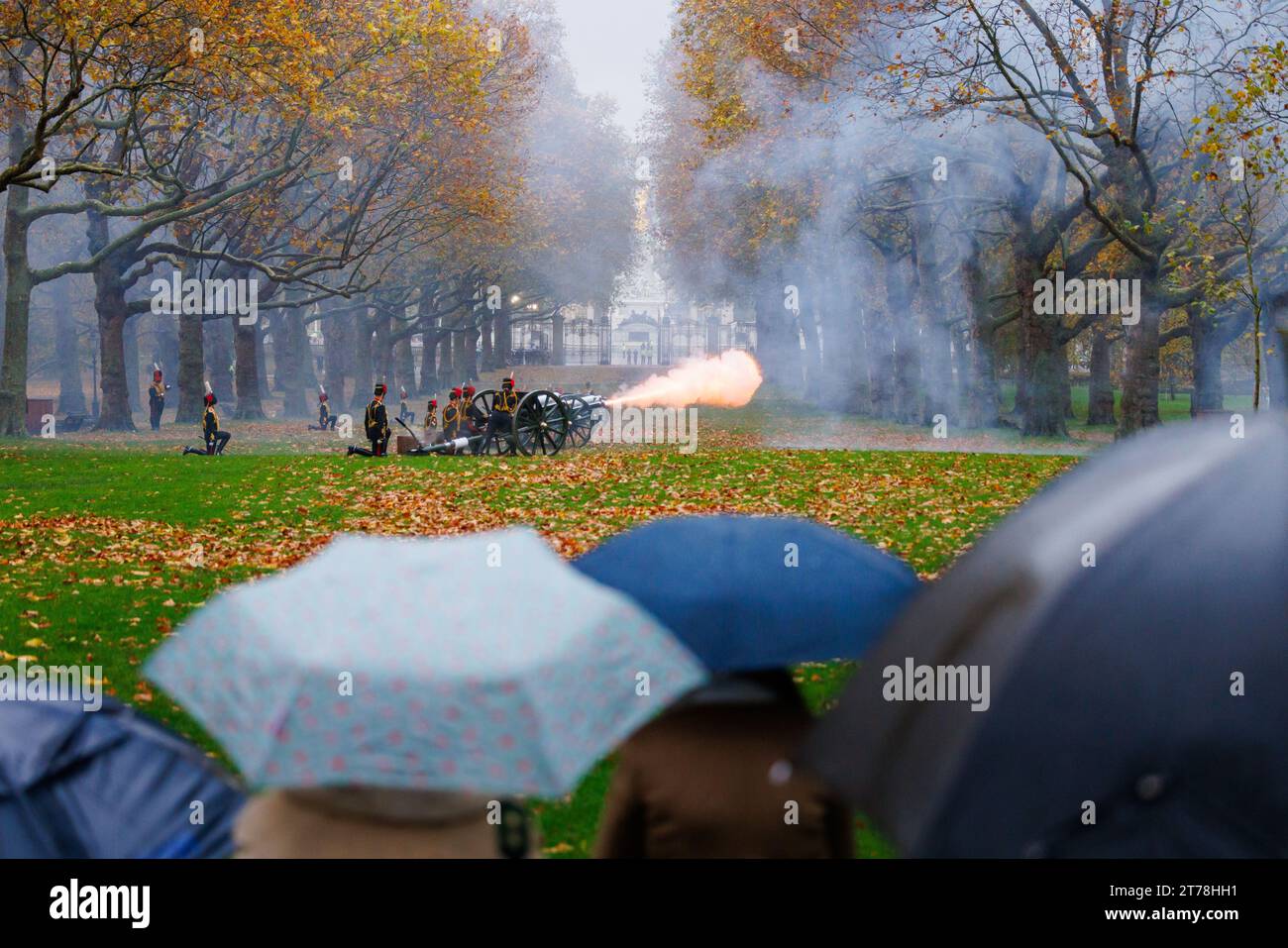 Green Park, Londra, Regno Unito. 14 novembre 2023. Gli spettatori guardano sotto la pioggia battente mentre la King's Troop Royal Horse Artillery sparano una pistola del 41 Royal salute a Green Park per il 75° compleanno di sua Maestà il Re. I soldati, i cavalli e le pistole della King's Troop Royal Horse Artillery indossano un'uniforme completa che include giacche intrecciate in oro e cappelli busby. 71 cavalli che tiravano sei cannoni da 13 libbre della prima guerra mondiale spararono colpi di artiglieria a intervalli di dieci secondi fino a quando non furono sparati quarantuno colpi. Foto di Amanda Rose/Alamy Live News Foto Stock