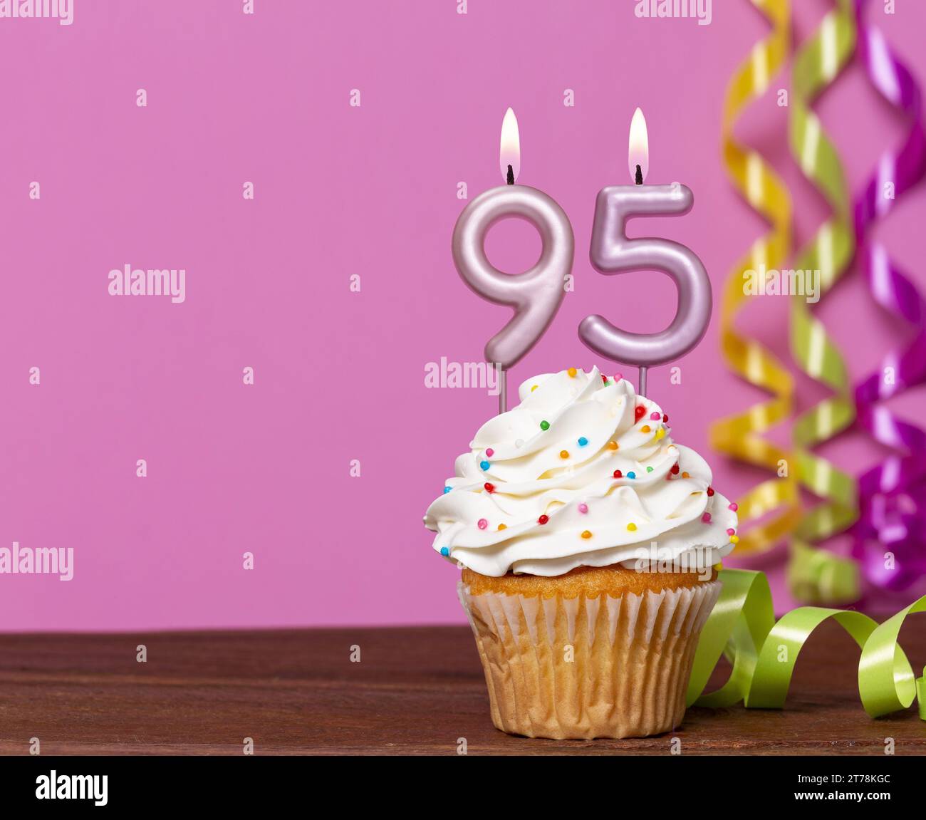 Torta di compleanno con candela numero 95 - su sfondo rosa. Foto Stock