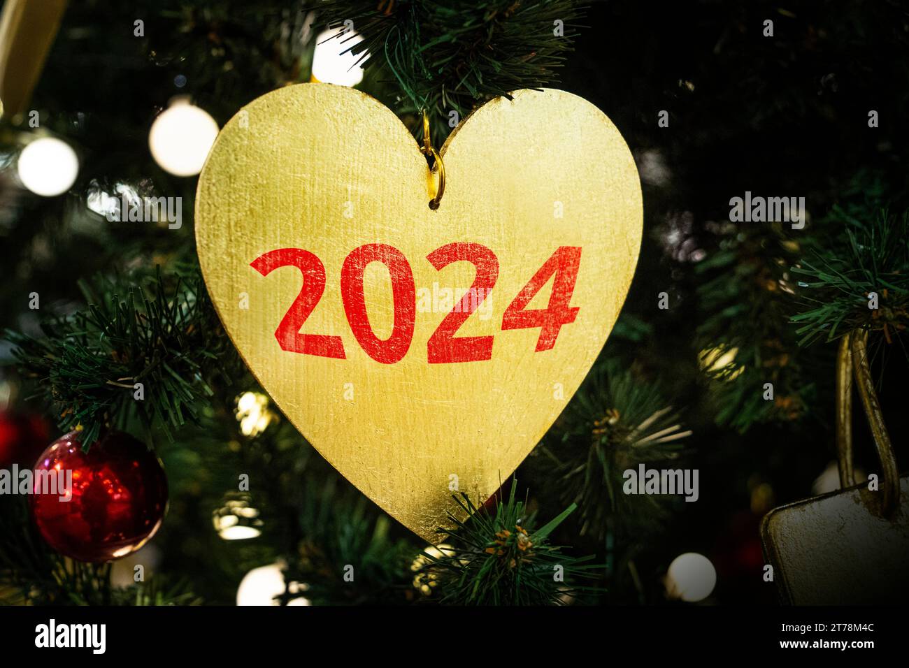 Layout creativo realizzato con rami dell'albero di Natale con decorazione a cuore. Love New Year Concert. 2024 Foto Stock