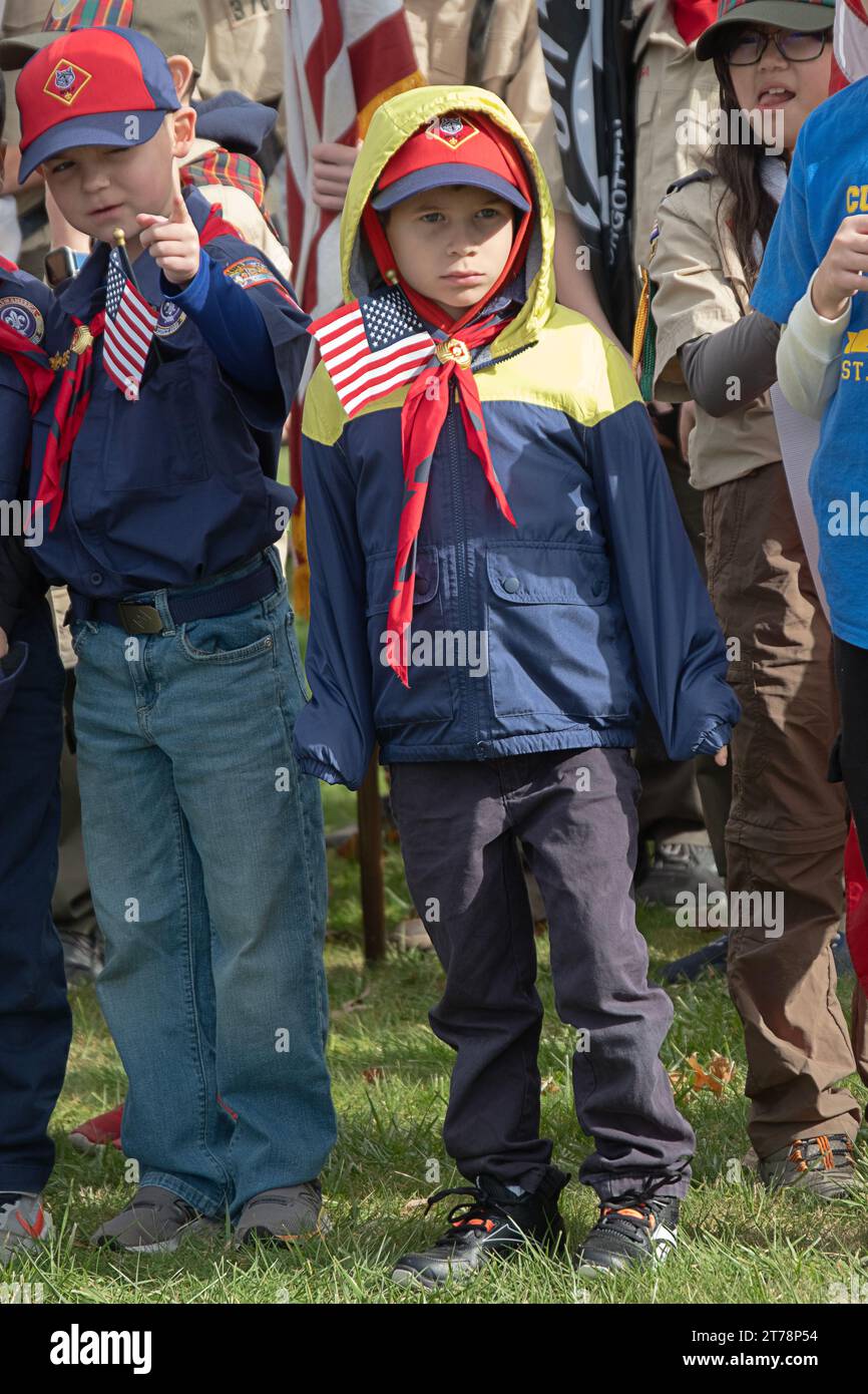 Alla Veterans Day Parade del 2023 a Somers, New York, un simpatico Cub Scout indossa una bandiera americana nella giacca. A una cerimonia Foto Stock