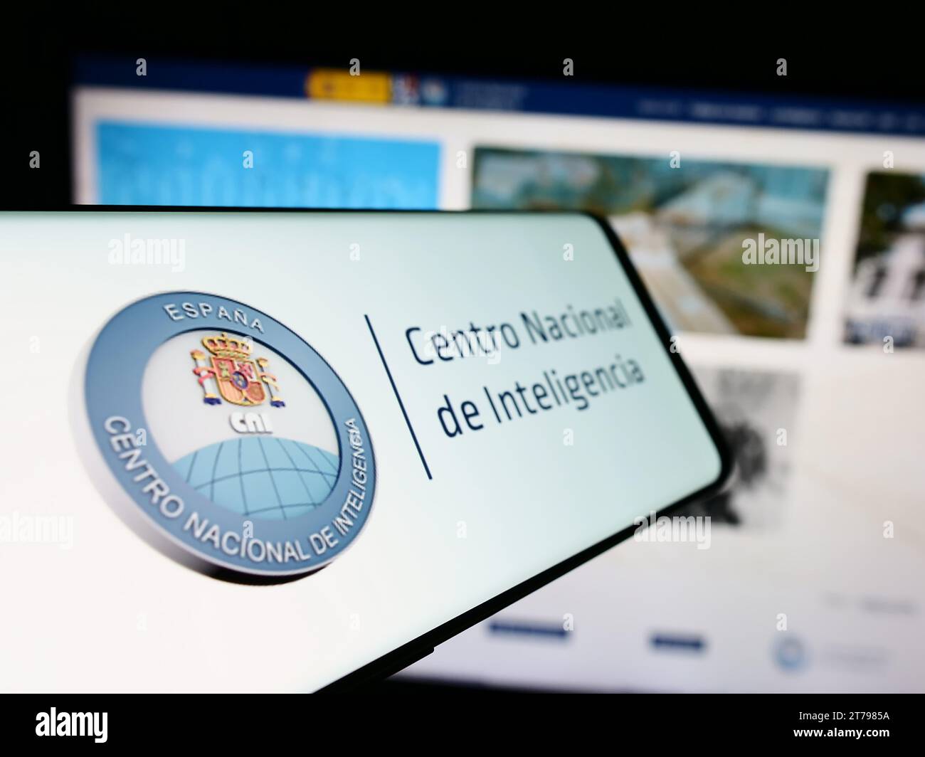 Cellulare con logo dell'agenzia di intelligence Centro Nacional de Inteligencia (CNI) davanti al sito web. Mettere a fuoco il display centrale sinistro del telefono. Foto Stock