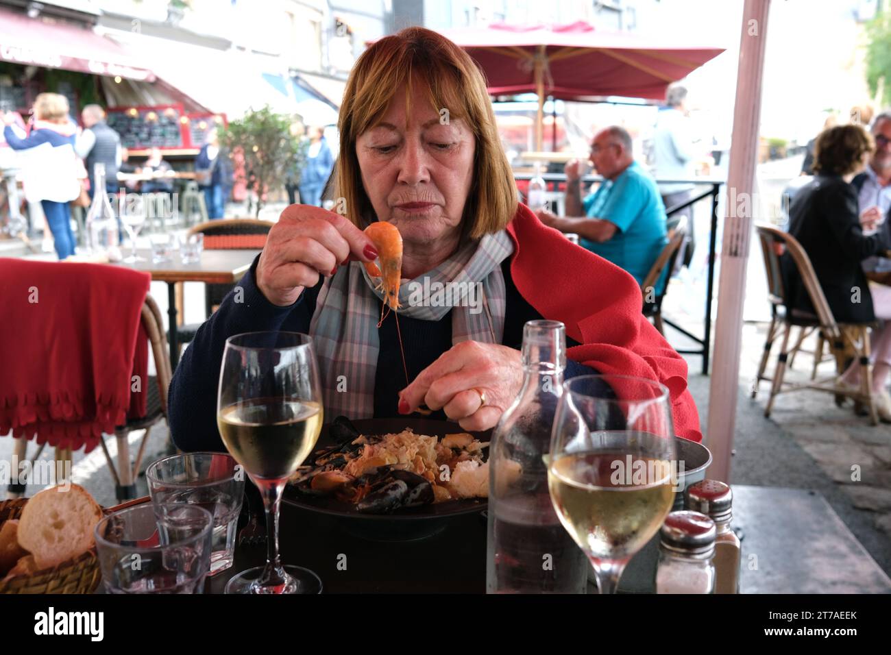 Donna turistica peeling gamberi al ristorante di Honfleur, Francia, Francia, Normandia, 2023 Foto Stock