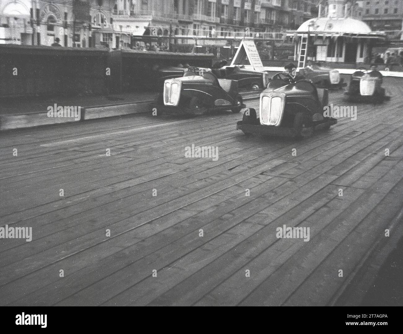 Anni '1950, storici, giovani che ubriacano auto "dogem" elettriche o go-kart, su una pista di legno in una località balneare vittoriana, Inghilterra, Regno Unito, forse a Great Yarmouth. Foto Stock