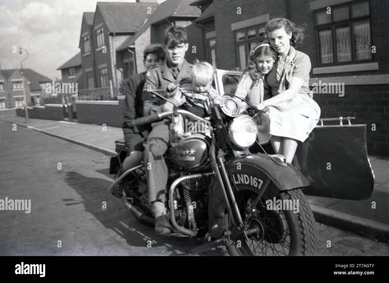 Anni '1950, storica, fuori in una strada, una famiglia seduta su una motocicletta Harley Davidson e sidecar di produzione americana dell'epoca per una foto, Oldham, Inghilterra, Regno Unito. Foto Stock
