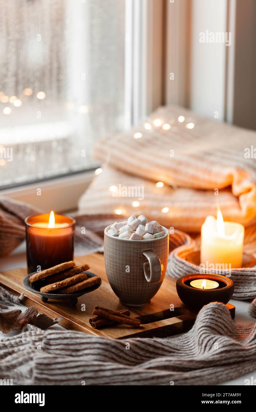 disposizione delle finestre calda e accogliente, concetto di inverno o autunno, caffè, candele di lancio luci Foto Stock